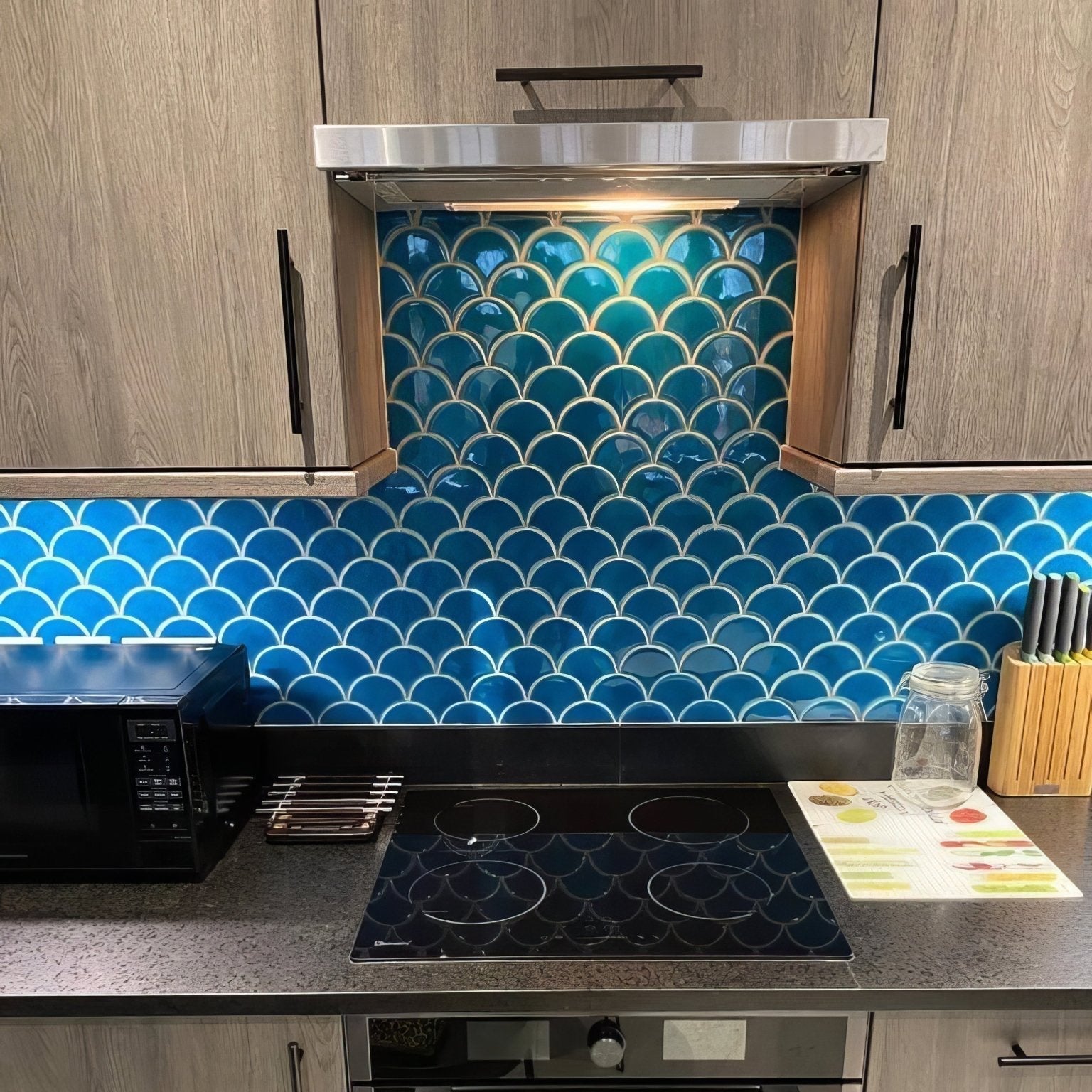Vibrant blue scalloped glass tile backsplash with white grout lines in atlantis porcelain mosaic ultramarine design