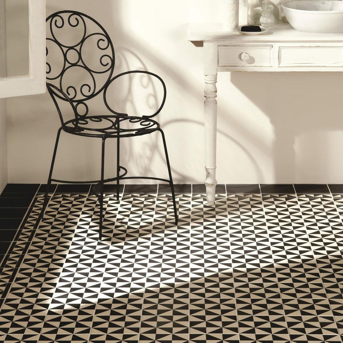 Avignon Black on Dover White black and white geometric pattern tiles with a black wrought iron chair