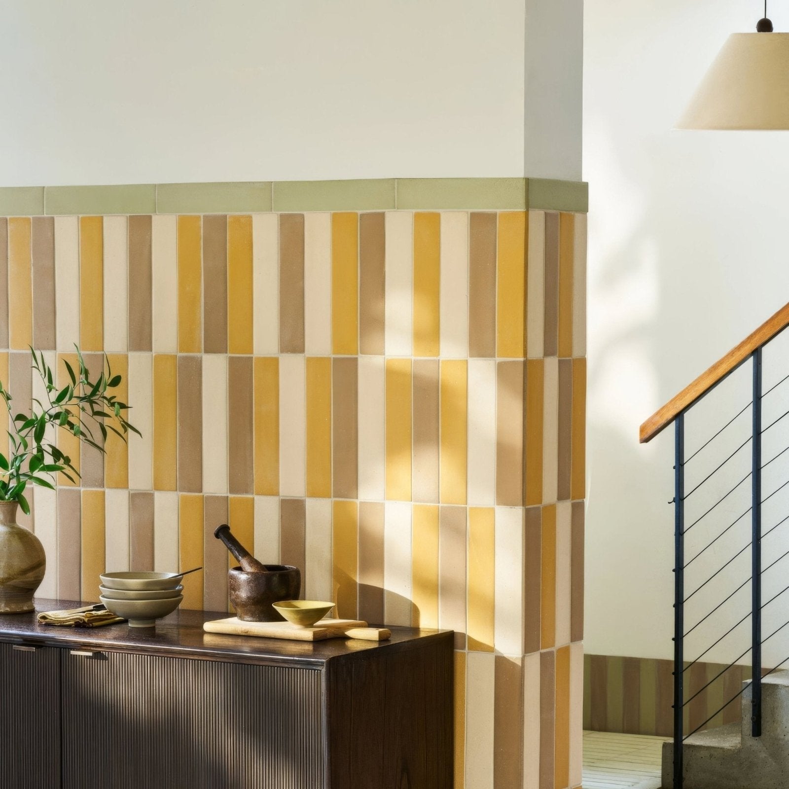 Vertical stripes of warm yellow beige and muted green ceramic tiles create a modern kitchen backsplash balance sand tile