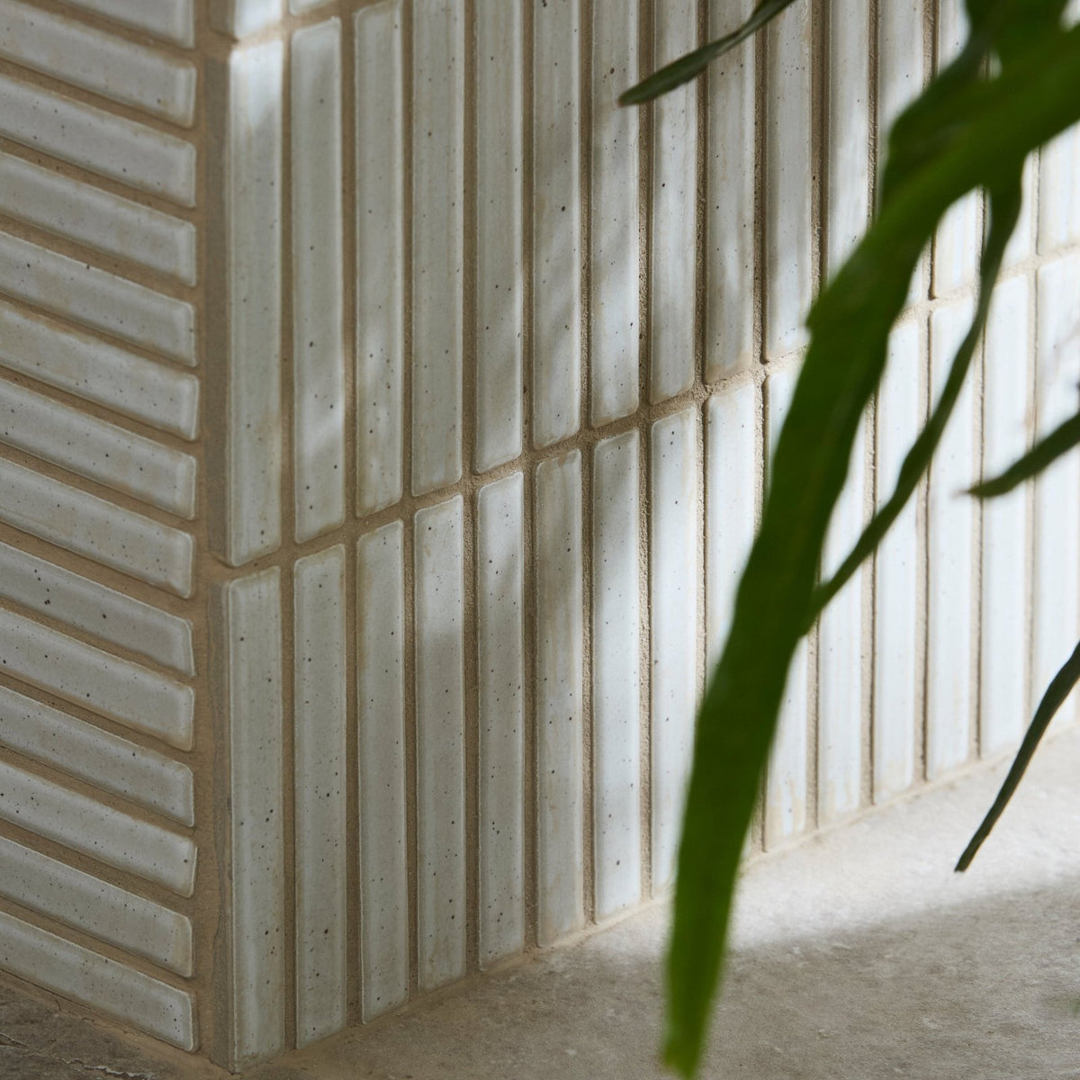 Off-white bamboo porcelain mosaic tiles with subtle speckles and vertical ridges for a modern minimalist wall