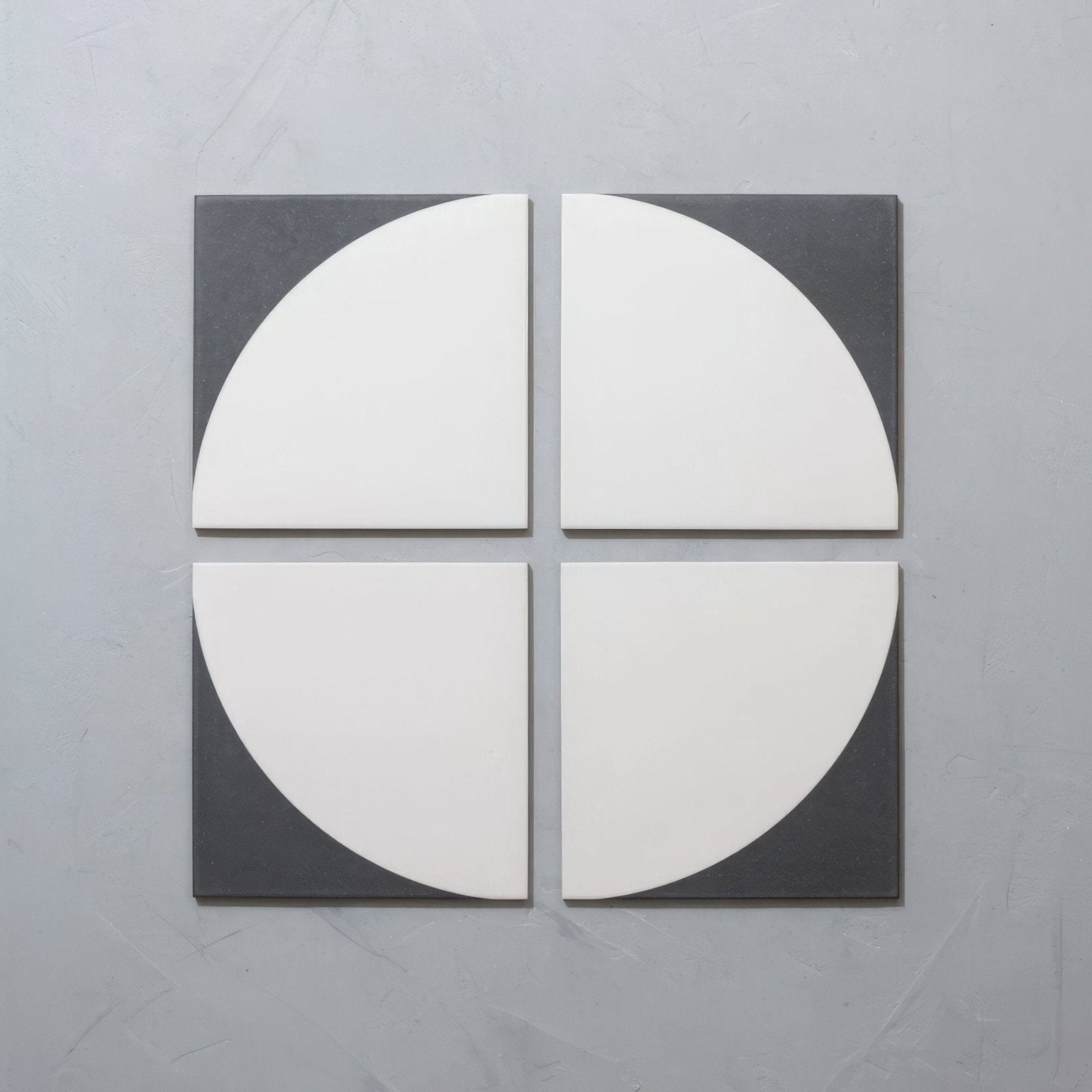 Modern geometric wall tile set featuring four white semi-circular porcelain pieces bordered by dark gray ceramic from bert & may arco old iron porcelain