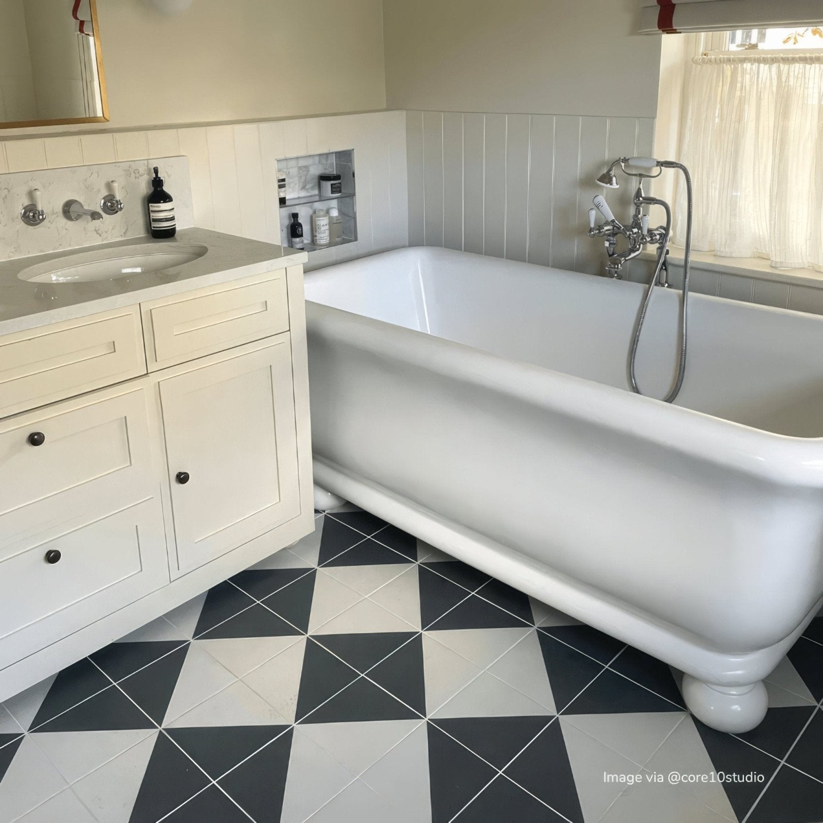 White porcelain clawfoot bathtub with rounded edges and decorative feet from bert & may black alalpardo porcelain collection