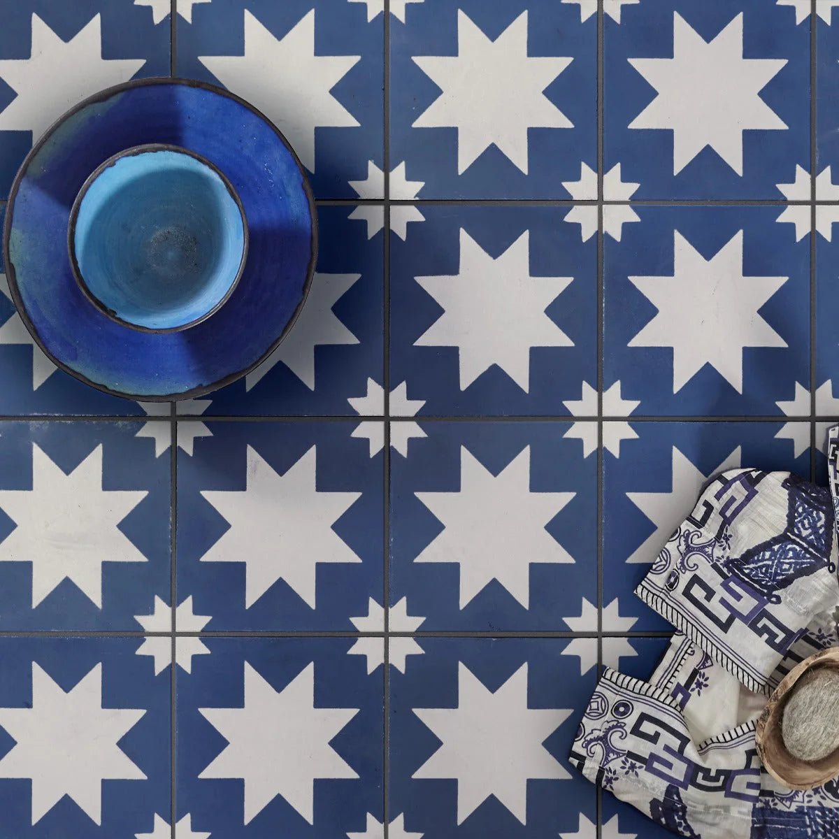 A deep blue bert and may pradena porcelain bowl with a glossy finish and slightly flared rim