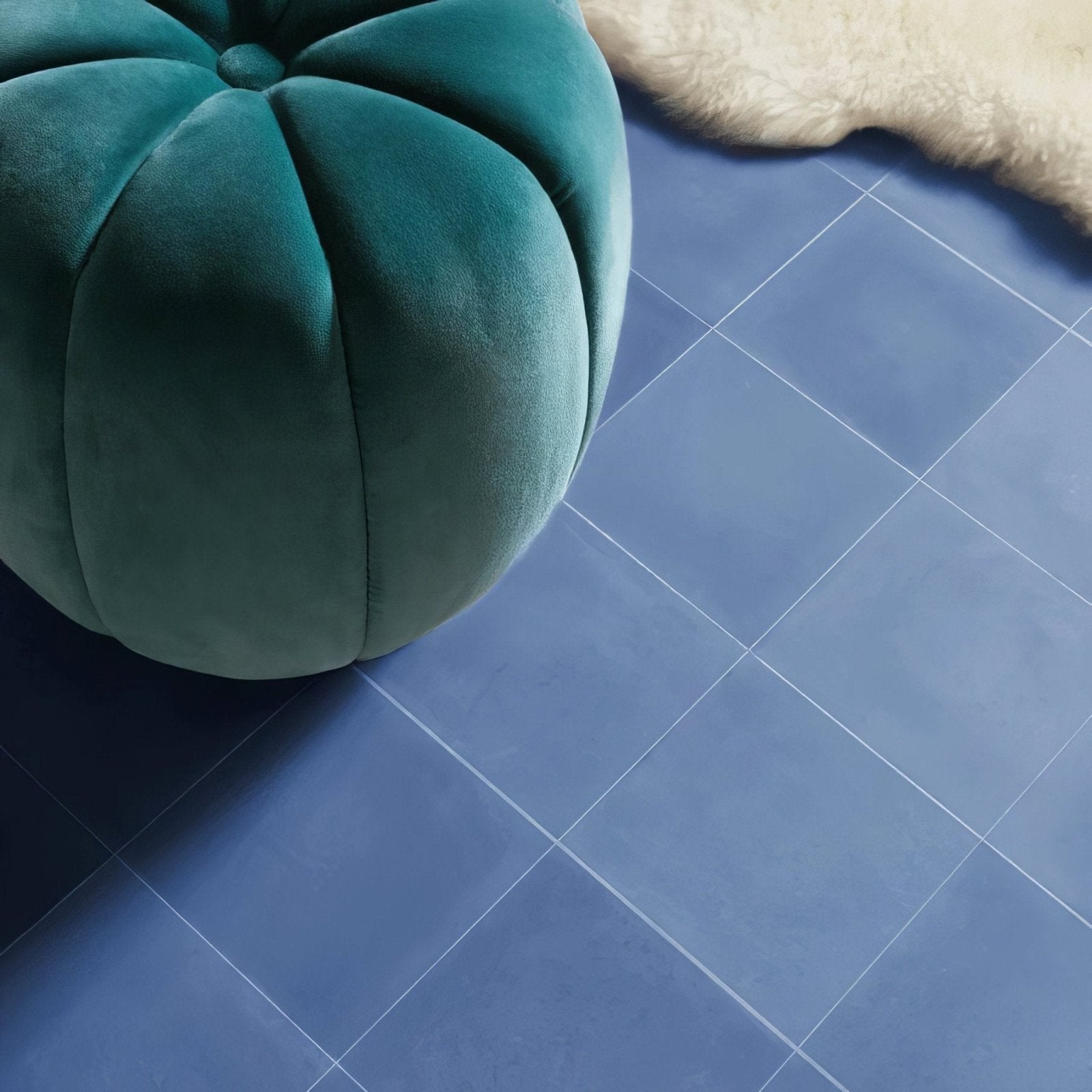 Teal velvet pouf with quilted pumpkin-shaped design paired with bert and may navy porcelain plain tile