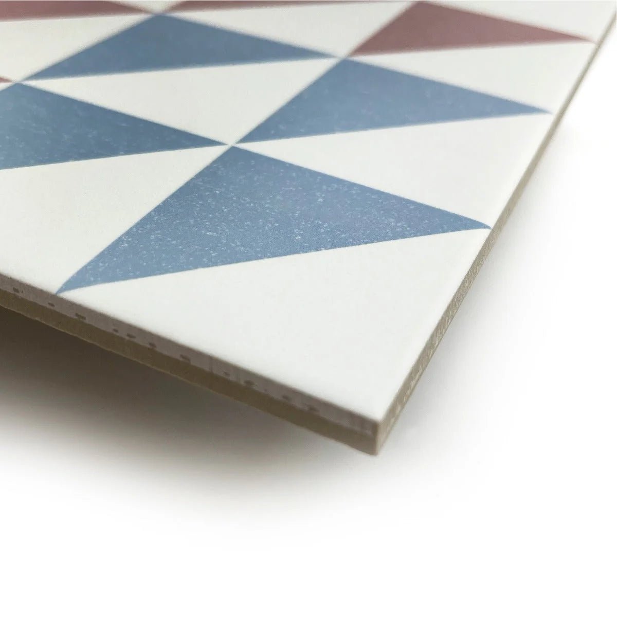 A square ceramic Bert & May Soho Majadas porcelain tile with a geometric pattern of blue white and muted red triangles