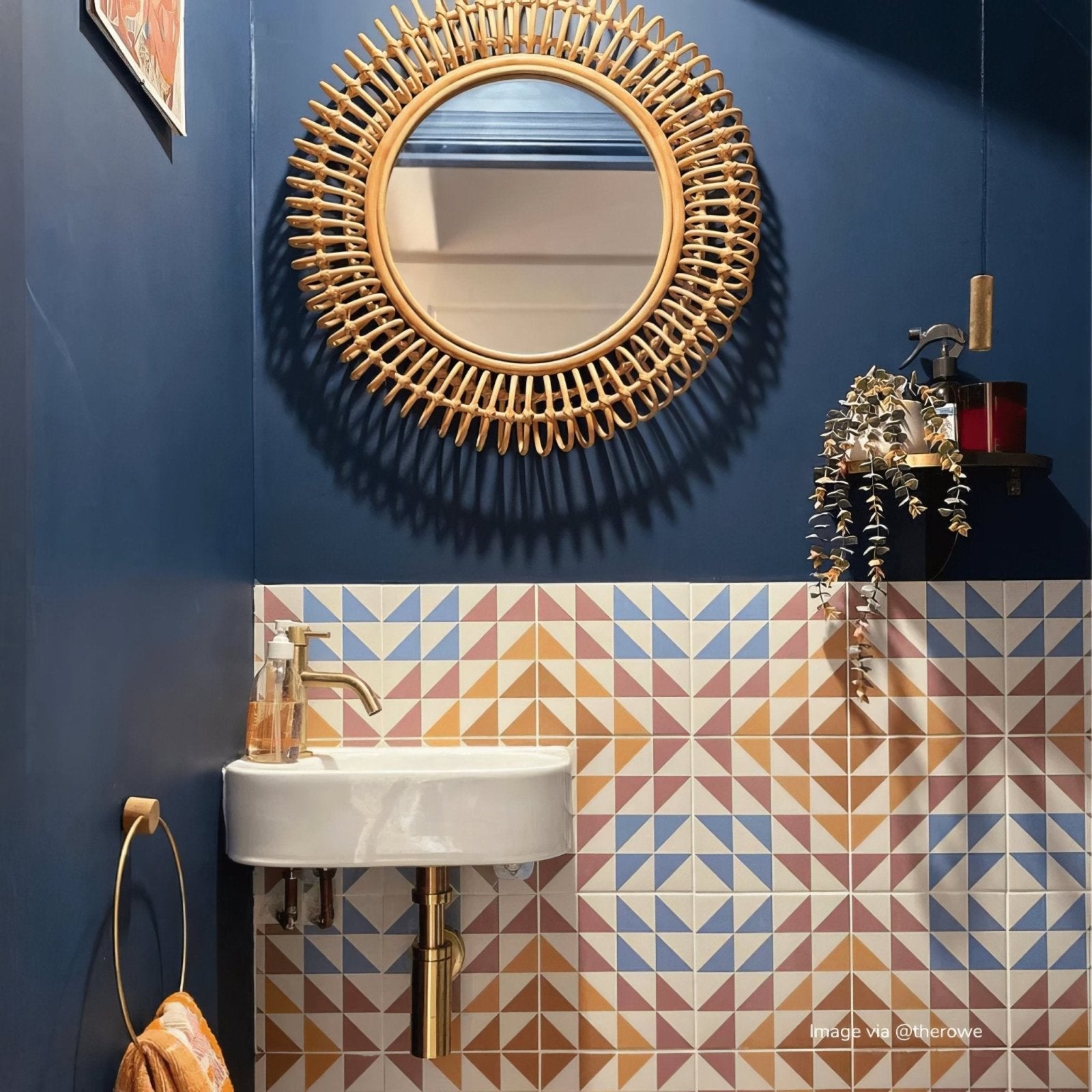 Rattan sunburst mirror with natural woven frame and circular glass center featured with bert and may soho majadas porcelain tile