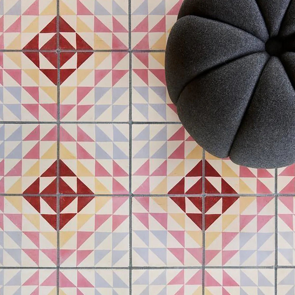 Dark gray plush flower-shaped pouf made with bert & may soho majadas porcelain tile accents