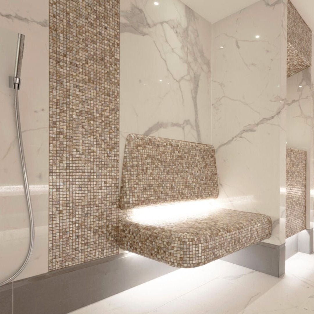 A sleek floating bench upholstered in shimmering beige mosaic tiles with integrated underlighting biscotti 25mm square
