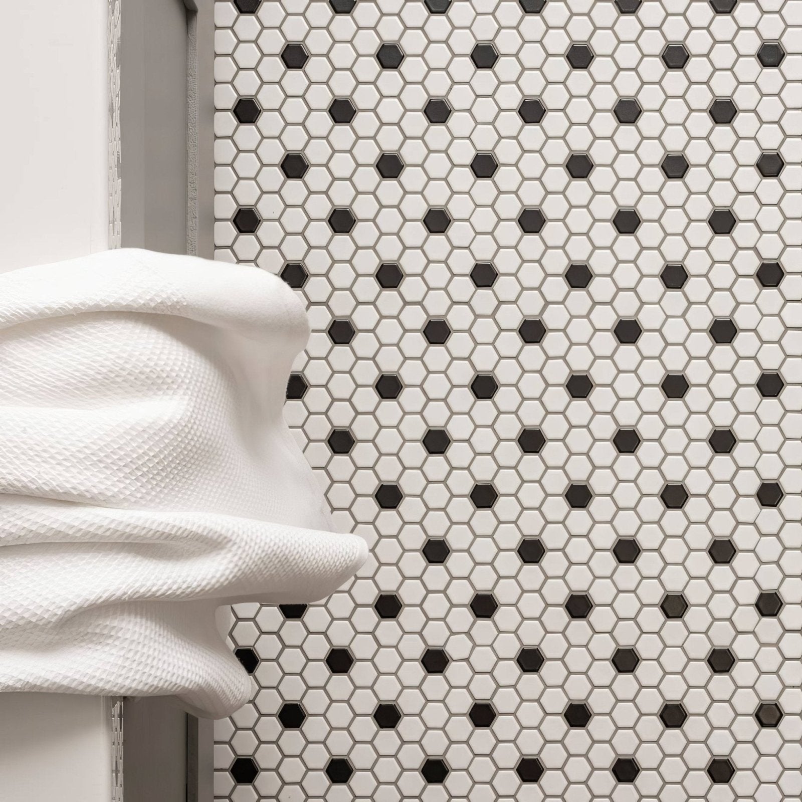 Black and White Honeycomb Floor Mosaic black and white hexagonal mosaic flooring with a white towel draped over it