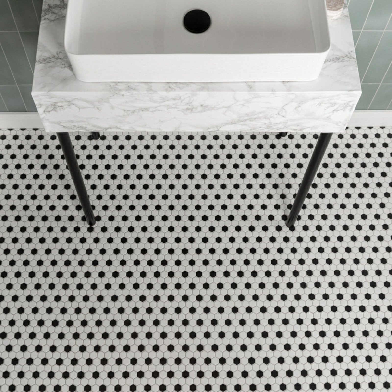 Black & White Honeycomb Floor Mosaic black and white hexagonal mosaic flooring with a white vessel sink on a marble countertop