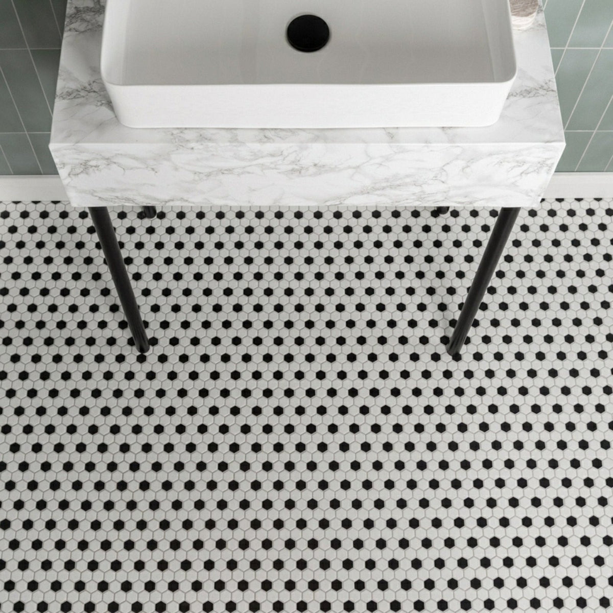 Black & White Honeycomb Floor Mosaic black and white hexagonal mosaic flooring with a white vessel sink on a marble countertop