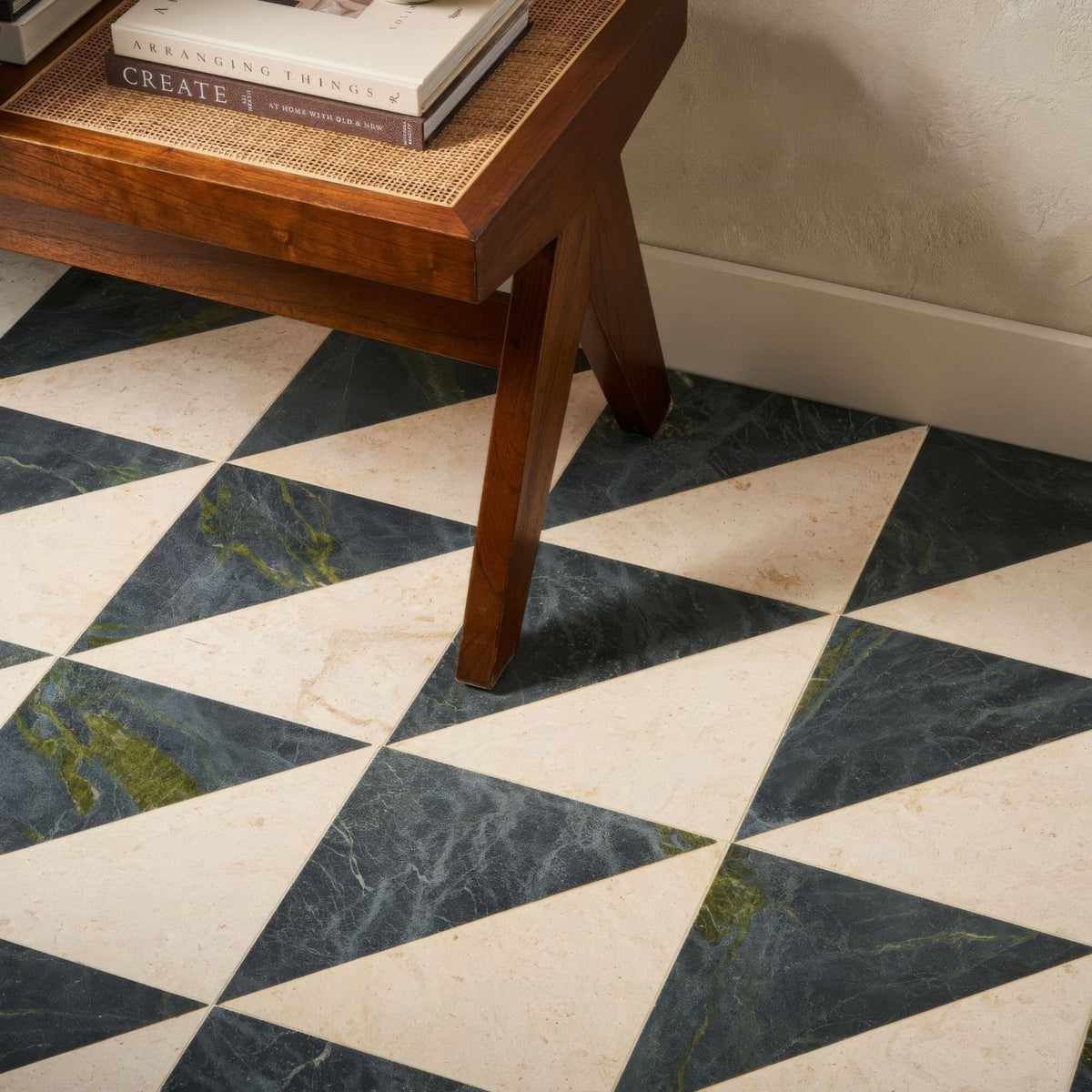 Geometric diamond-patterned floor tiles in contrasting dark green and creamy white marble in blends verde triangle design