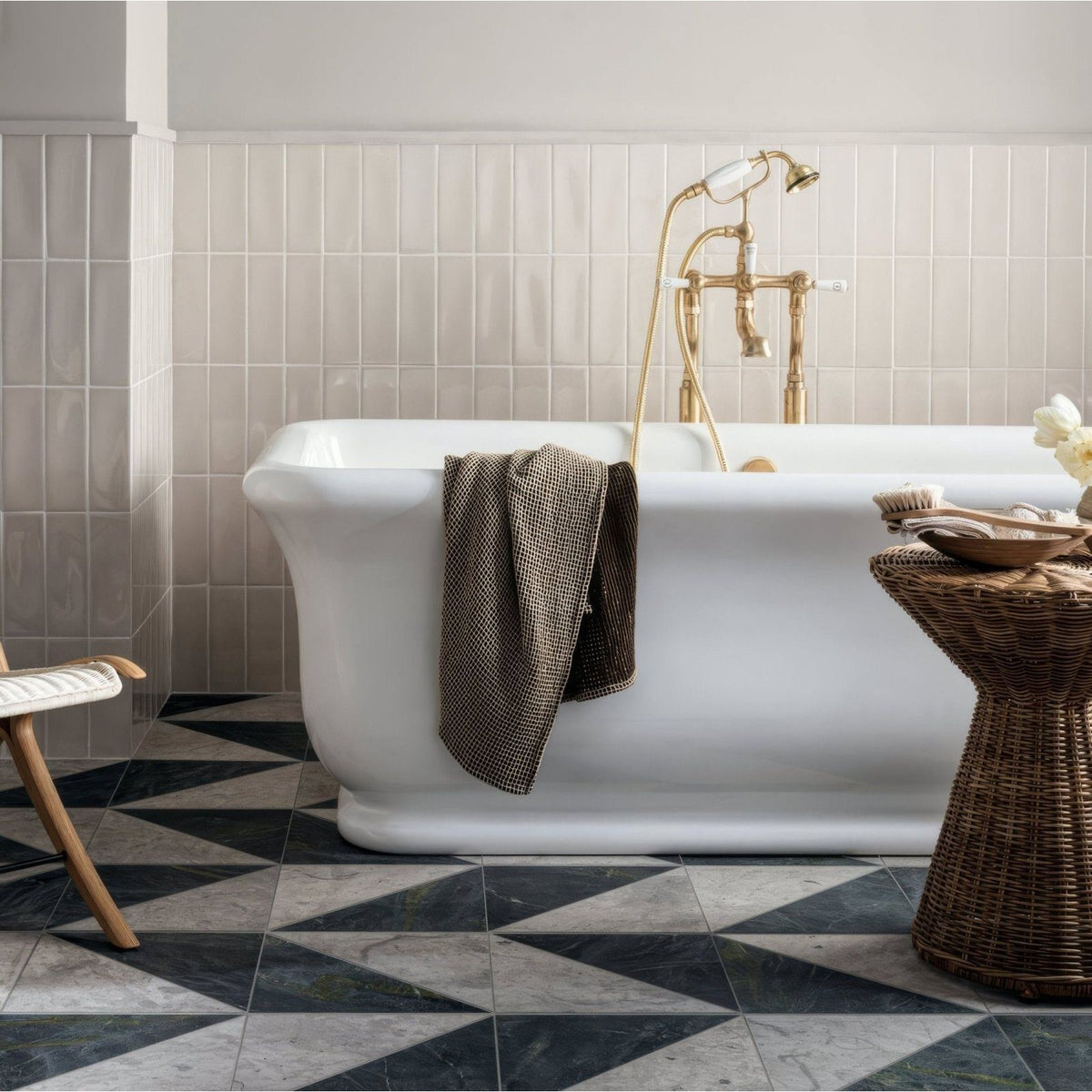 Blends Verde Triangle dark green marble triangle tiles with a white freestanding bathtub and gold fixtures