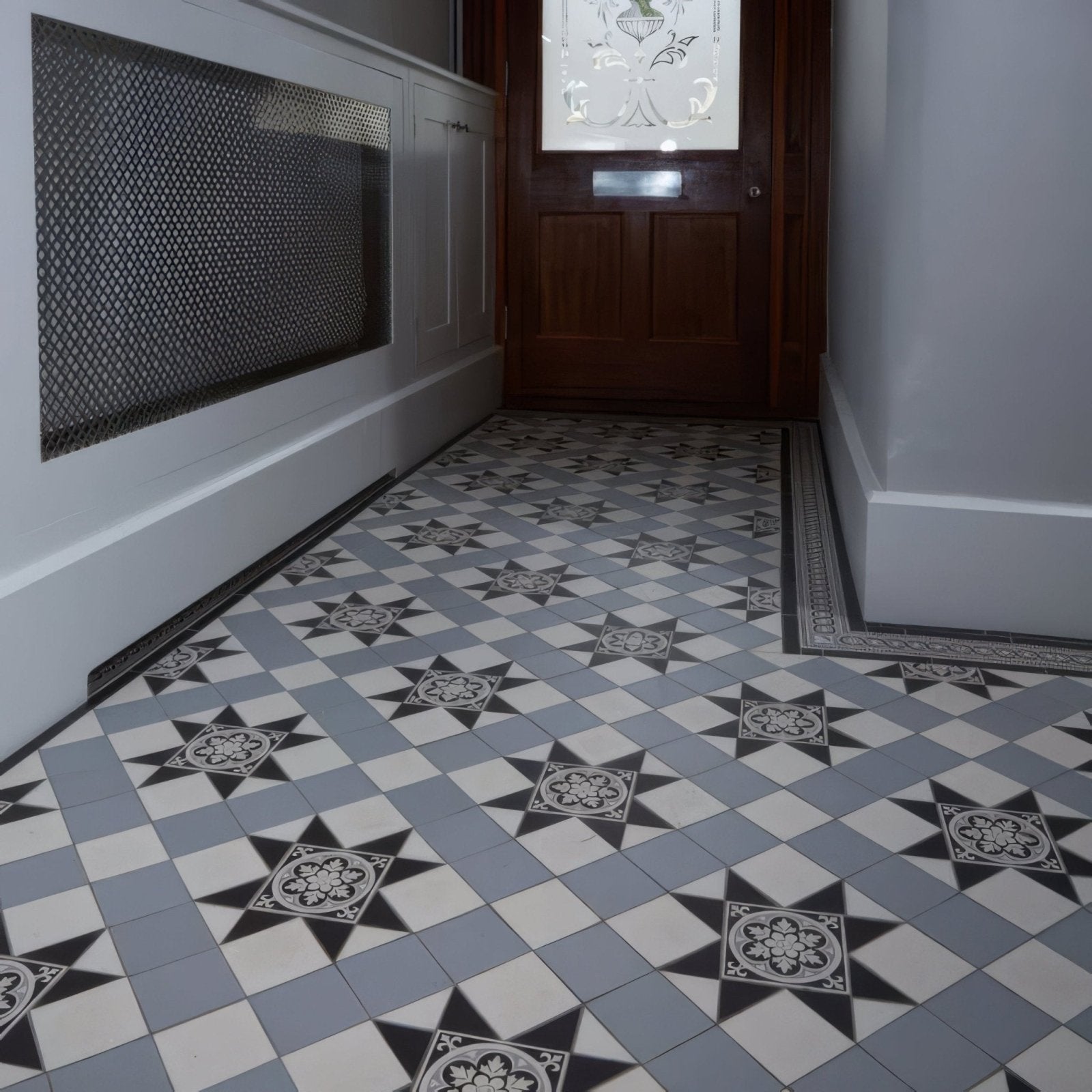 Gray and white geometric patterned floor tiles with black star accents from blenheim black dover white and grey collection