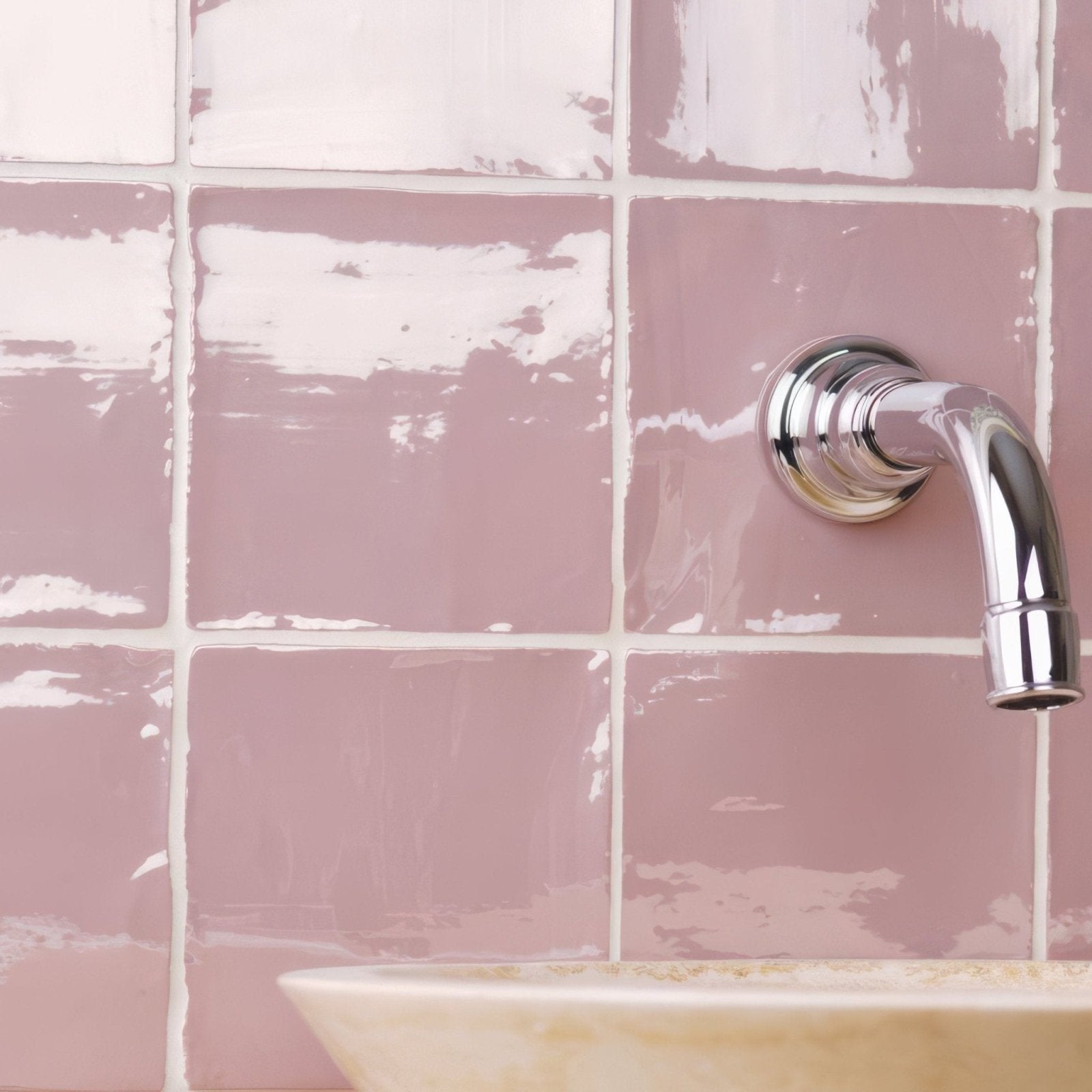 A sleek chrome finished bathroom faucet with a curved spout and polished finish in blossom field tile setting