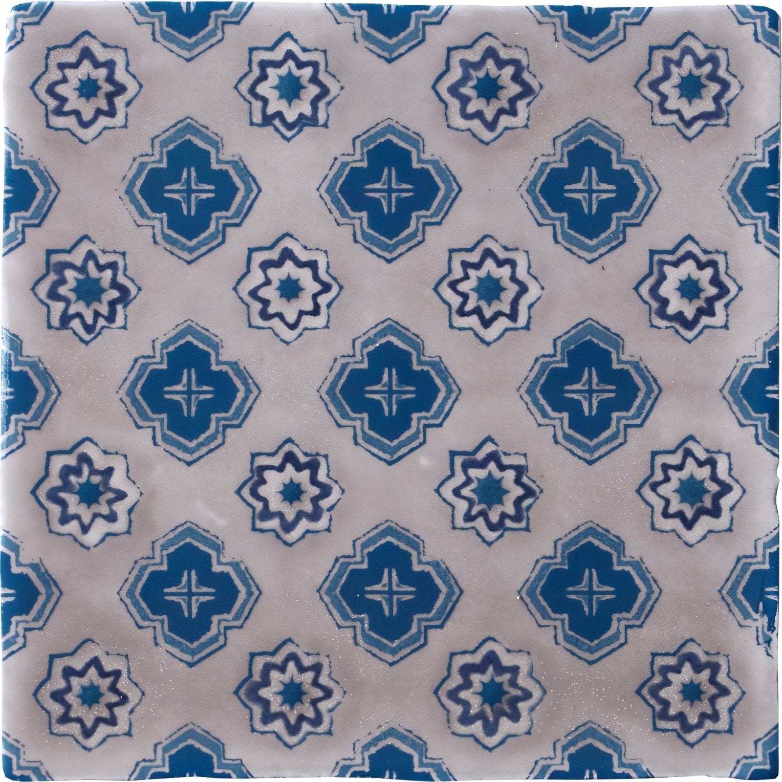 Blue and white patterned ceramic tile with geometric starburst designs from bourron on truffle collection