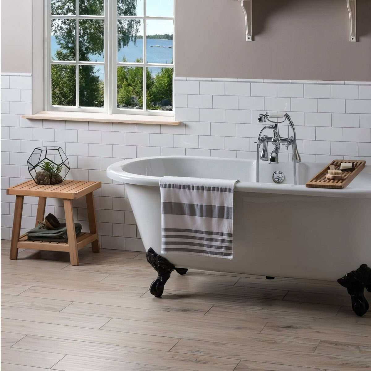 White clawfoot bathtub with black feet and silver faucet against brilliant white half tile wall background