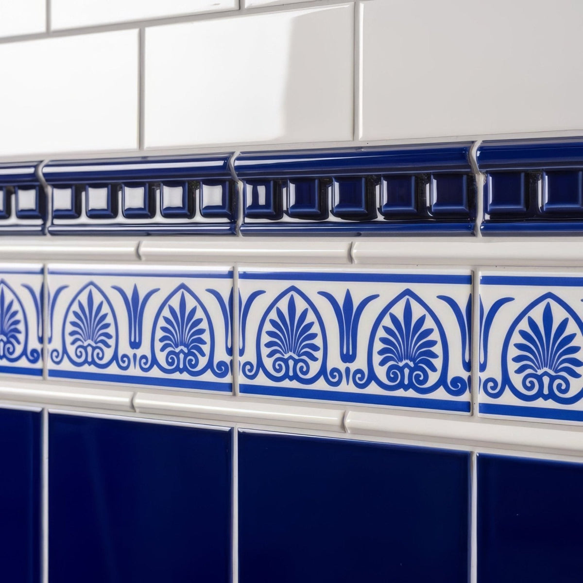 Blue and white ceramic tile border with ornate foliate patterns for brilliant white omega moulding trim