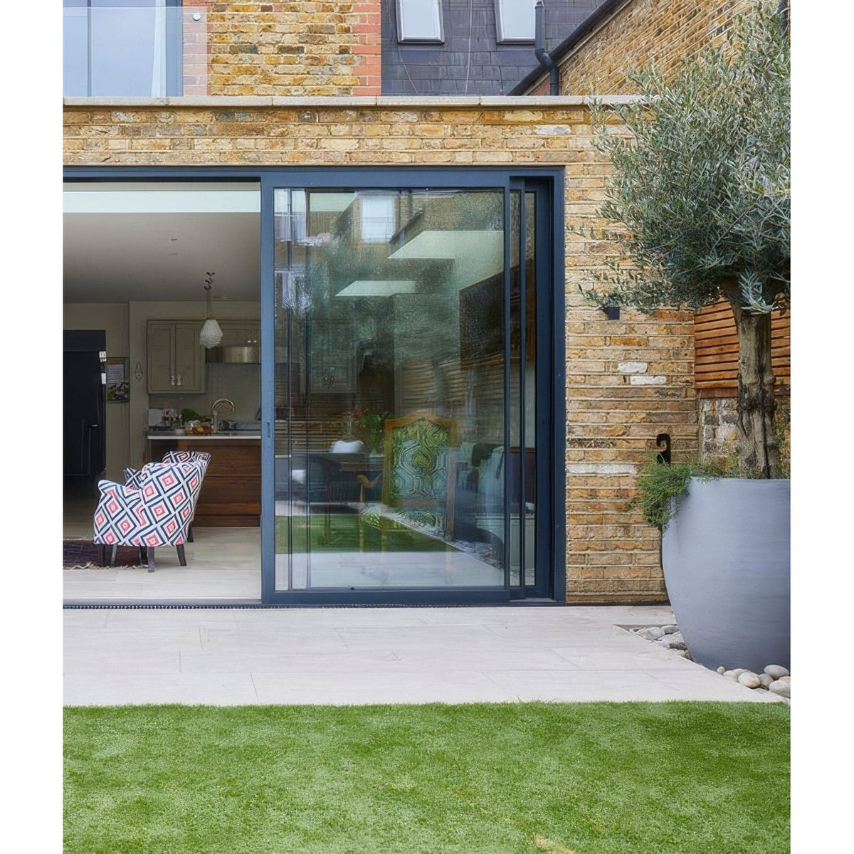 Modern navy blue framed sliding glass door with sleek minimalist design installed on buscot limestone paving etched finish