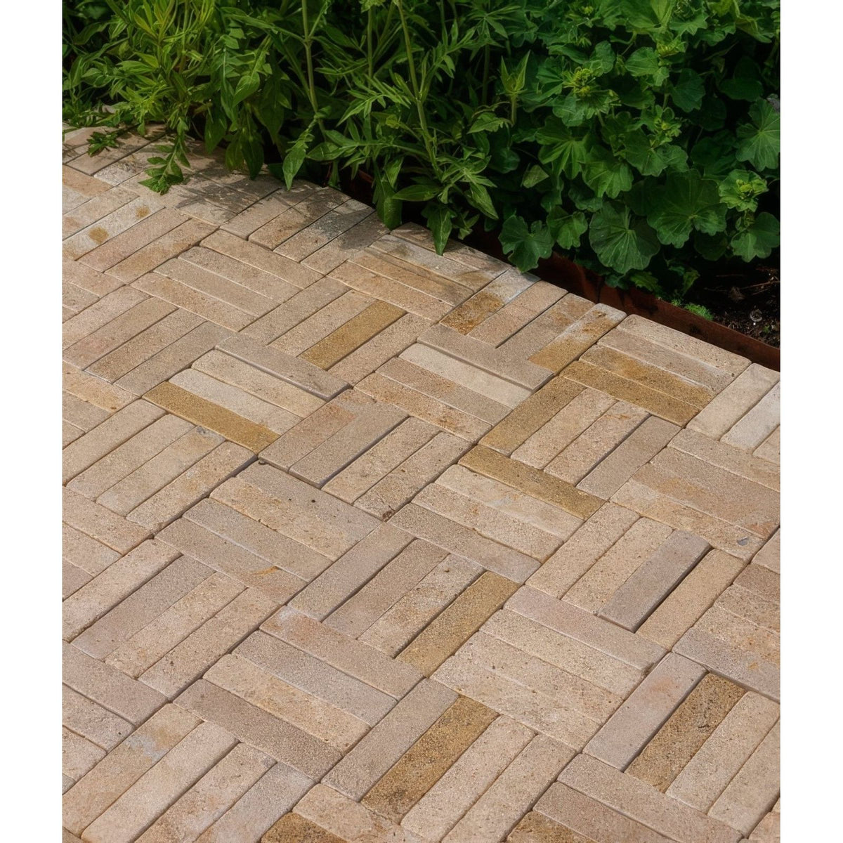 Beige and tan herringbone patterned buscot limestone tumbled and etched stone pavers for outdoor use