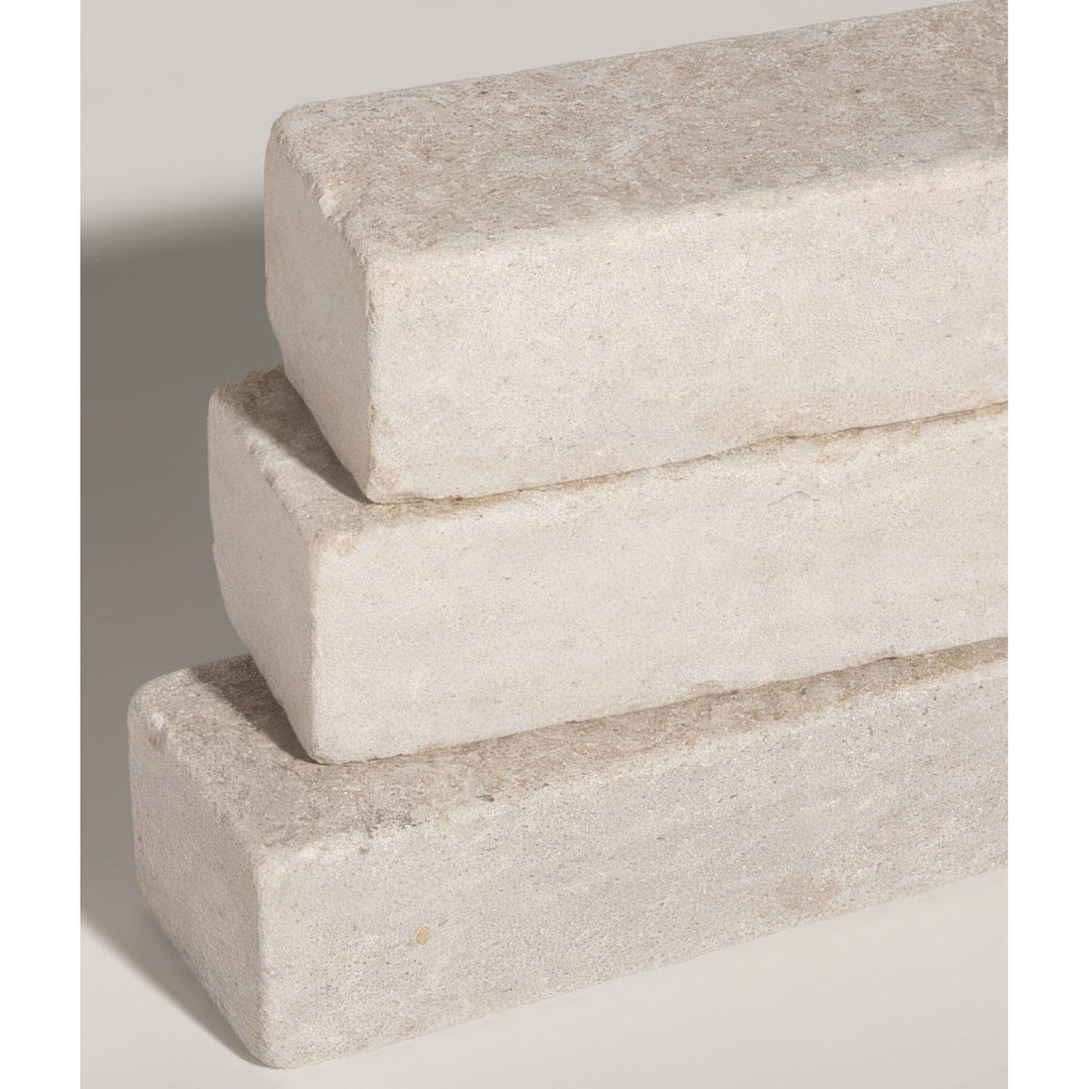 Stacked light gray buscot limestone tumbled and etched klinkers with rough textured surface for durable wall cladding