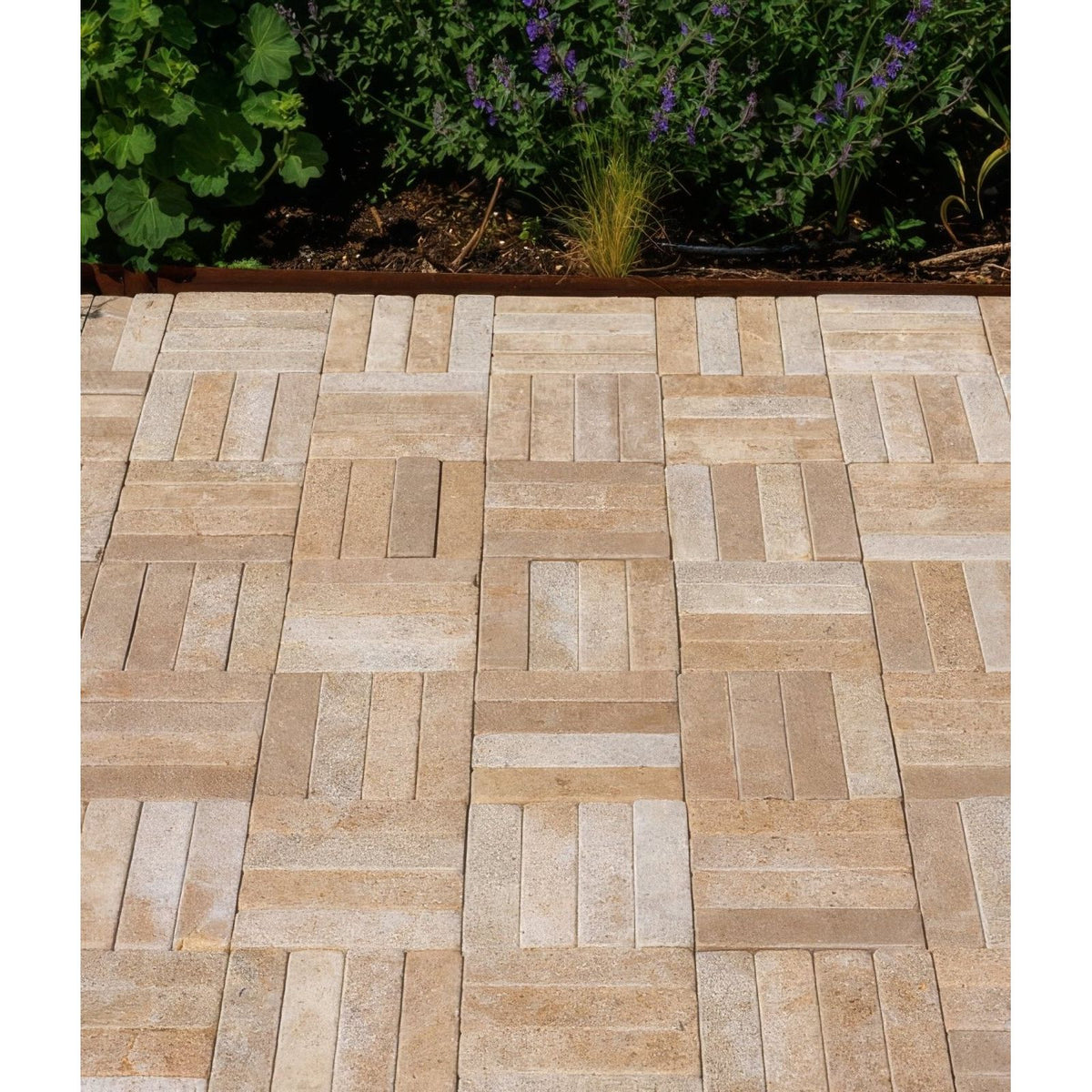 Beige and cream buscot limestone tumbled and etched klinkers stone pavers arranged in a herringbone pattern