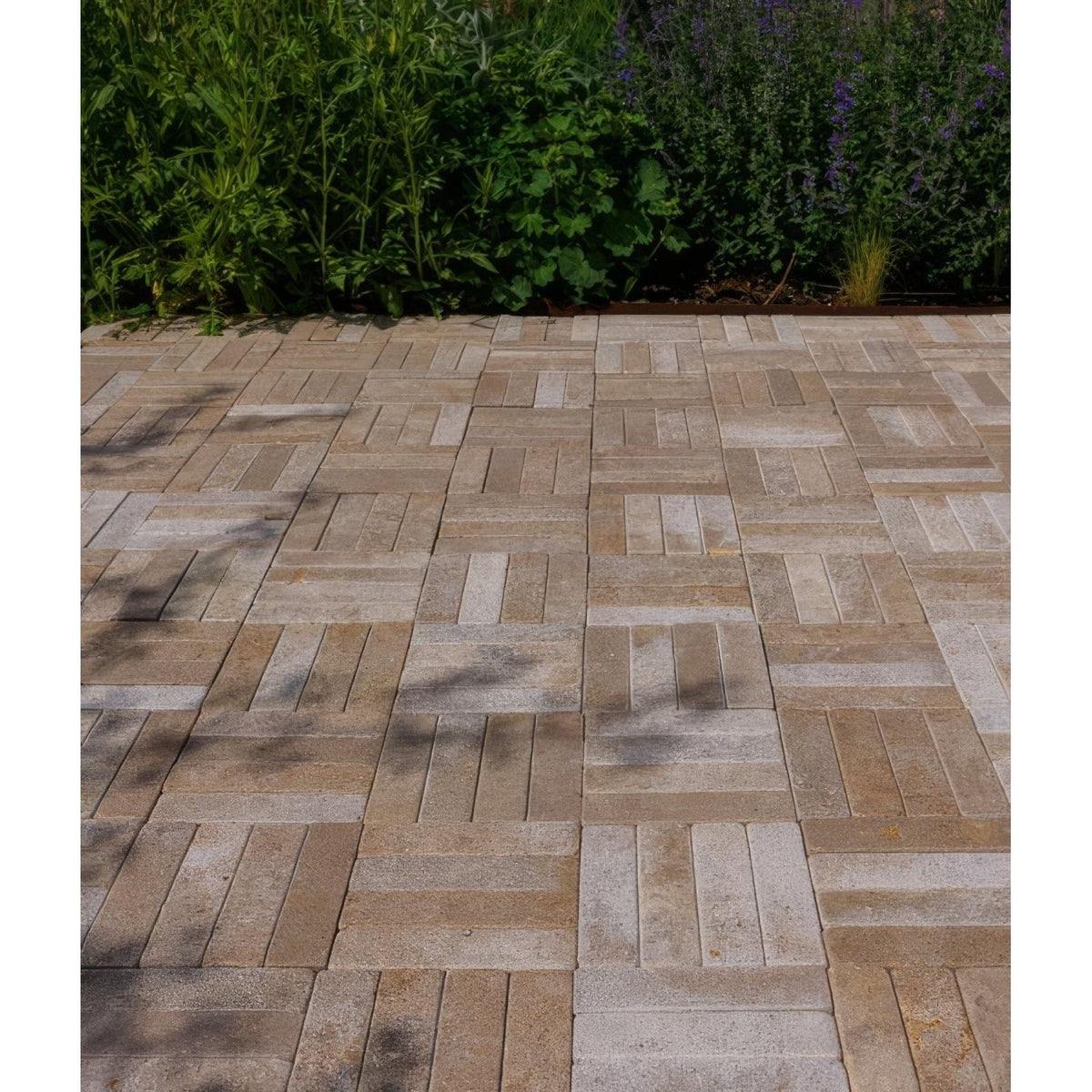 Interlocking beige and light gray buscot limestone tumbled and etched klinkers stone pavers in herringbone pattern