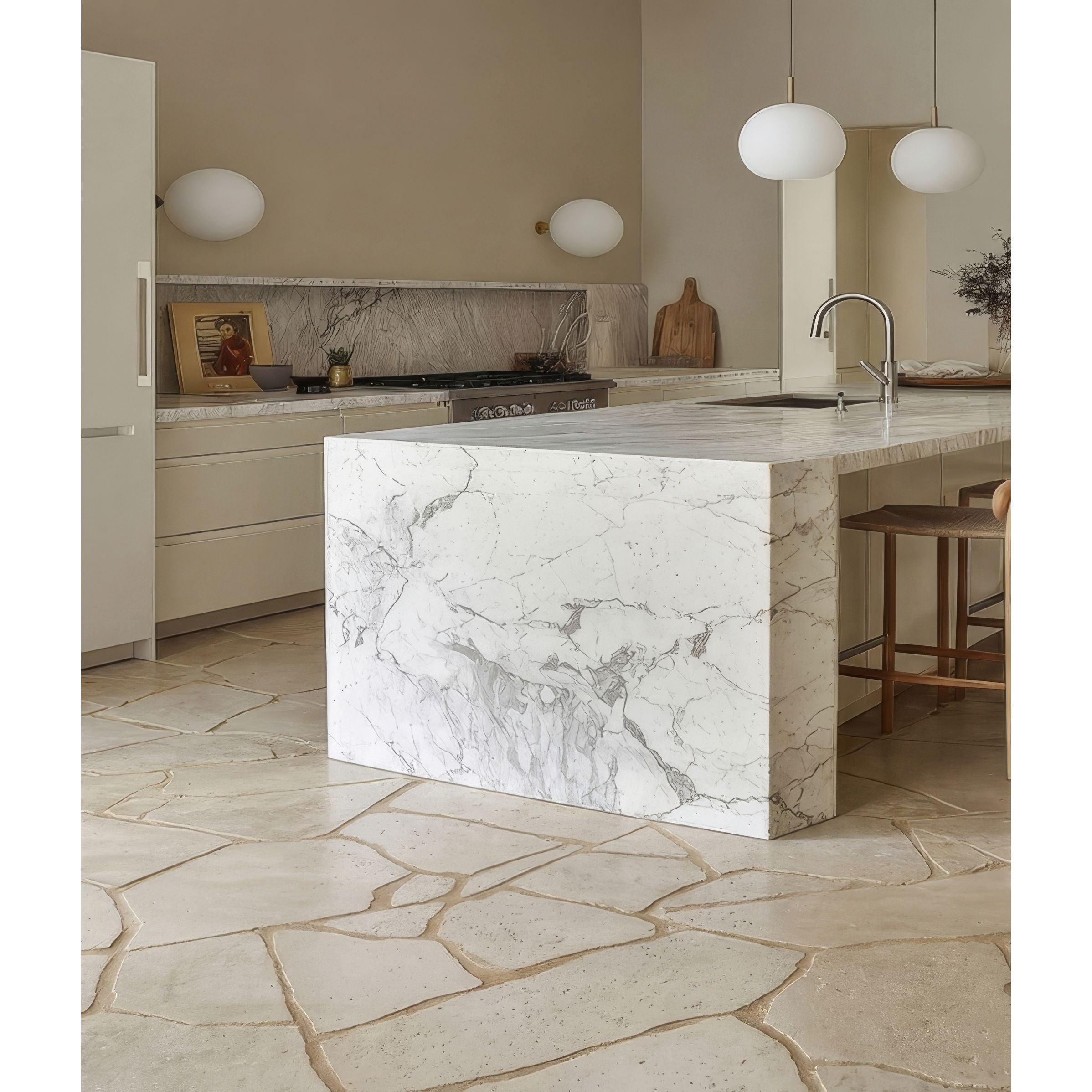 Modern kitchen with marble island and stone floor in Buscot Tumbled Pietra Pazza Limestone Tiles