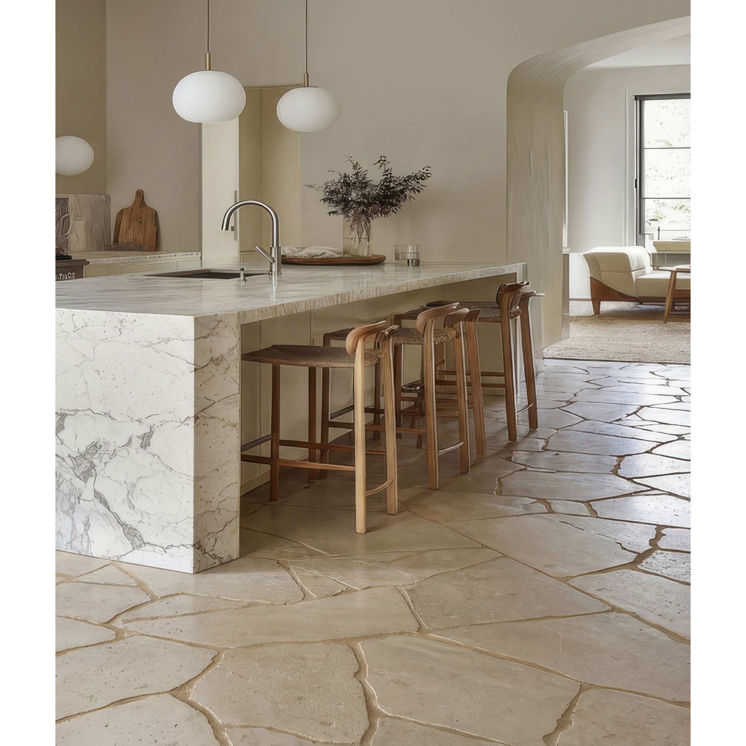 Modern kitchen with marble island and stone flooring in Buscot Tumbled Pietra Pazza Limestone Tiles
