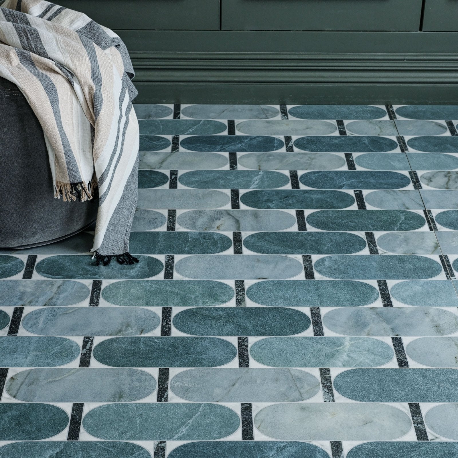 Byzantine porcelain lauro sculpted teal and white marble effect oval floor tiles with black grout lines