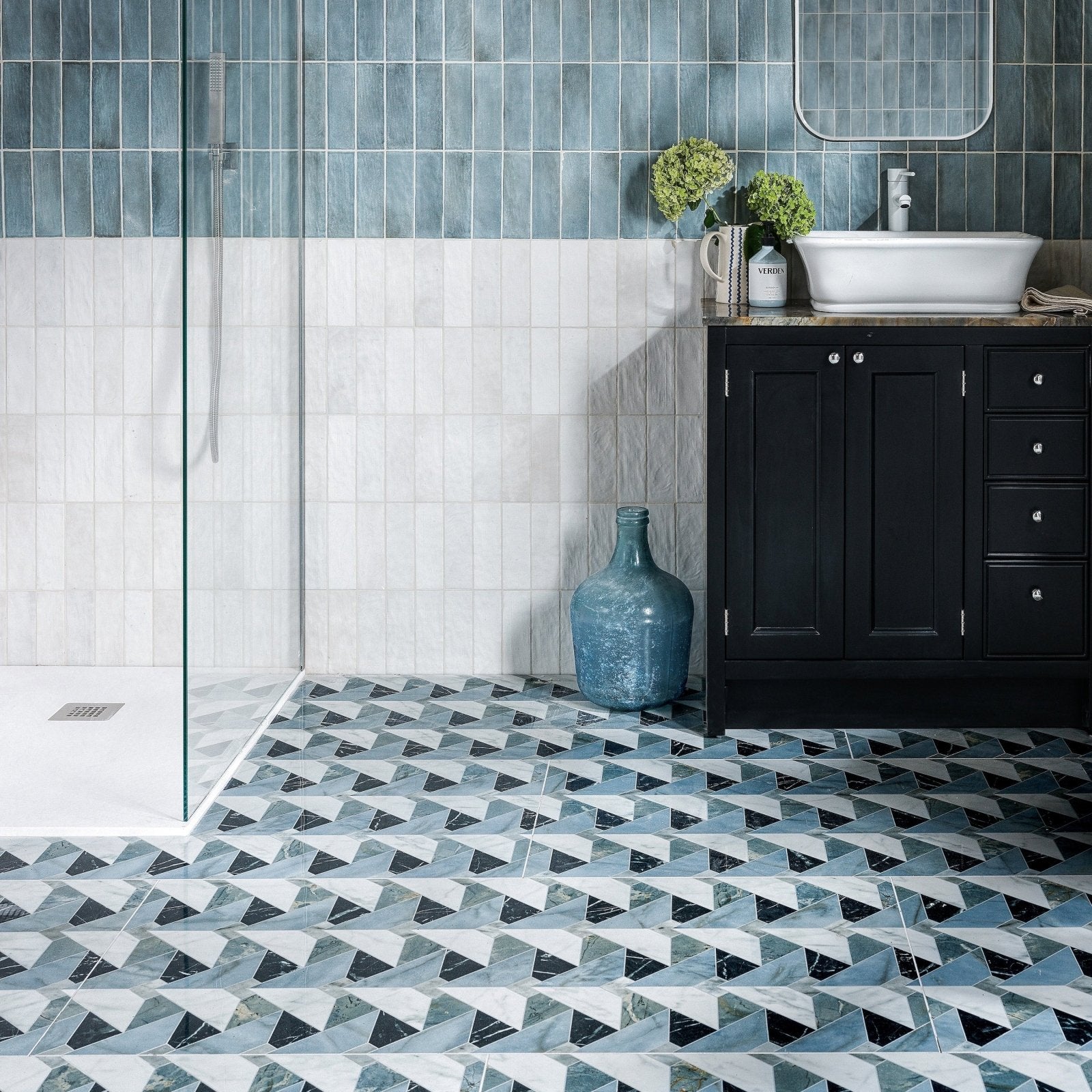 Byzantine Porcelain Seraph Sculpted geometric marble-effect porcelain tiles styled with a blue ceramic vase by a black vanity