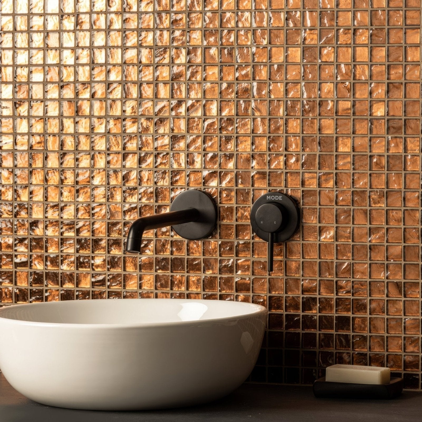 Byzantium Bronze Glass Mosaic gold glass mosaic behind a white vessel sink