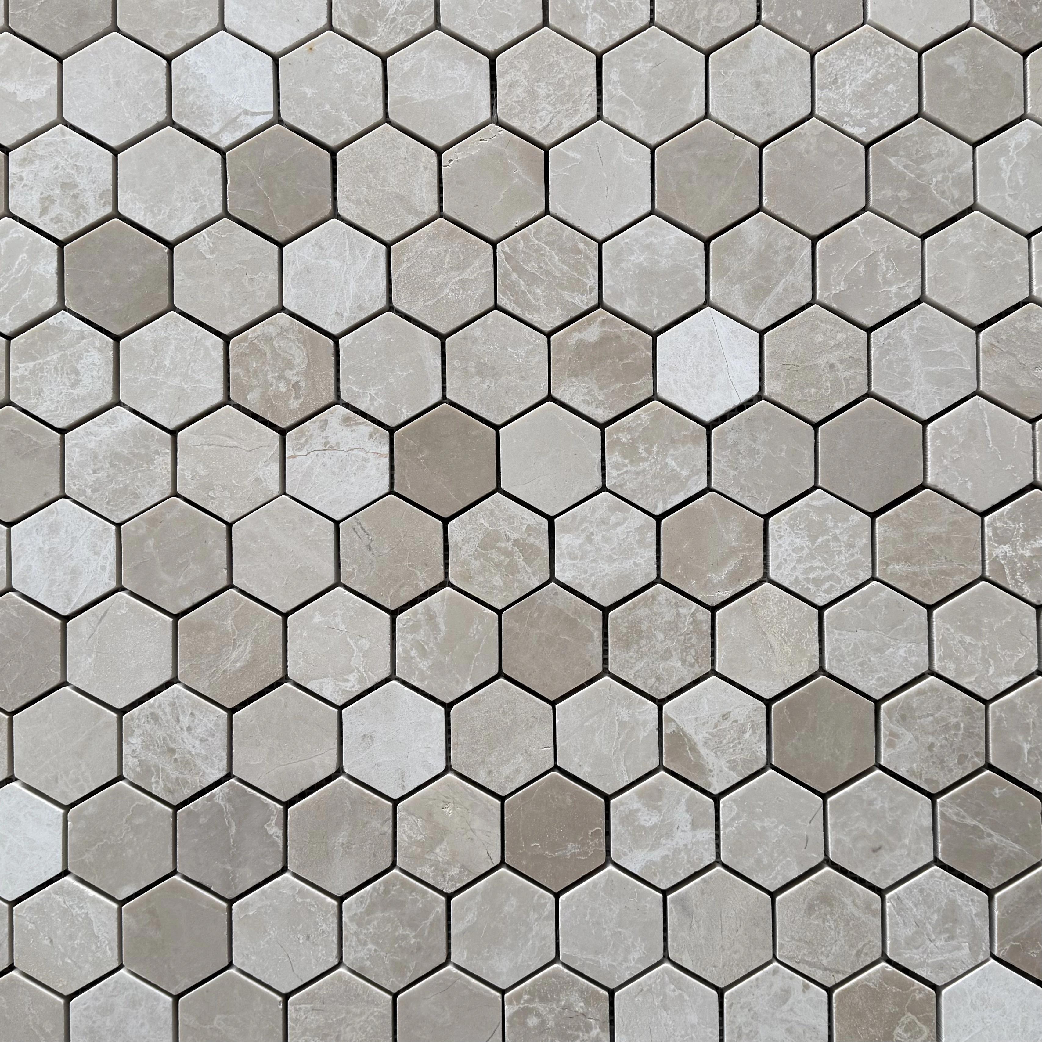 Close detail of polished Belgravia Beige marble hexagons showing warm sand tone and taupe drift