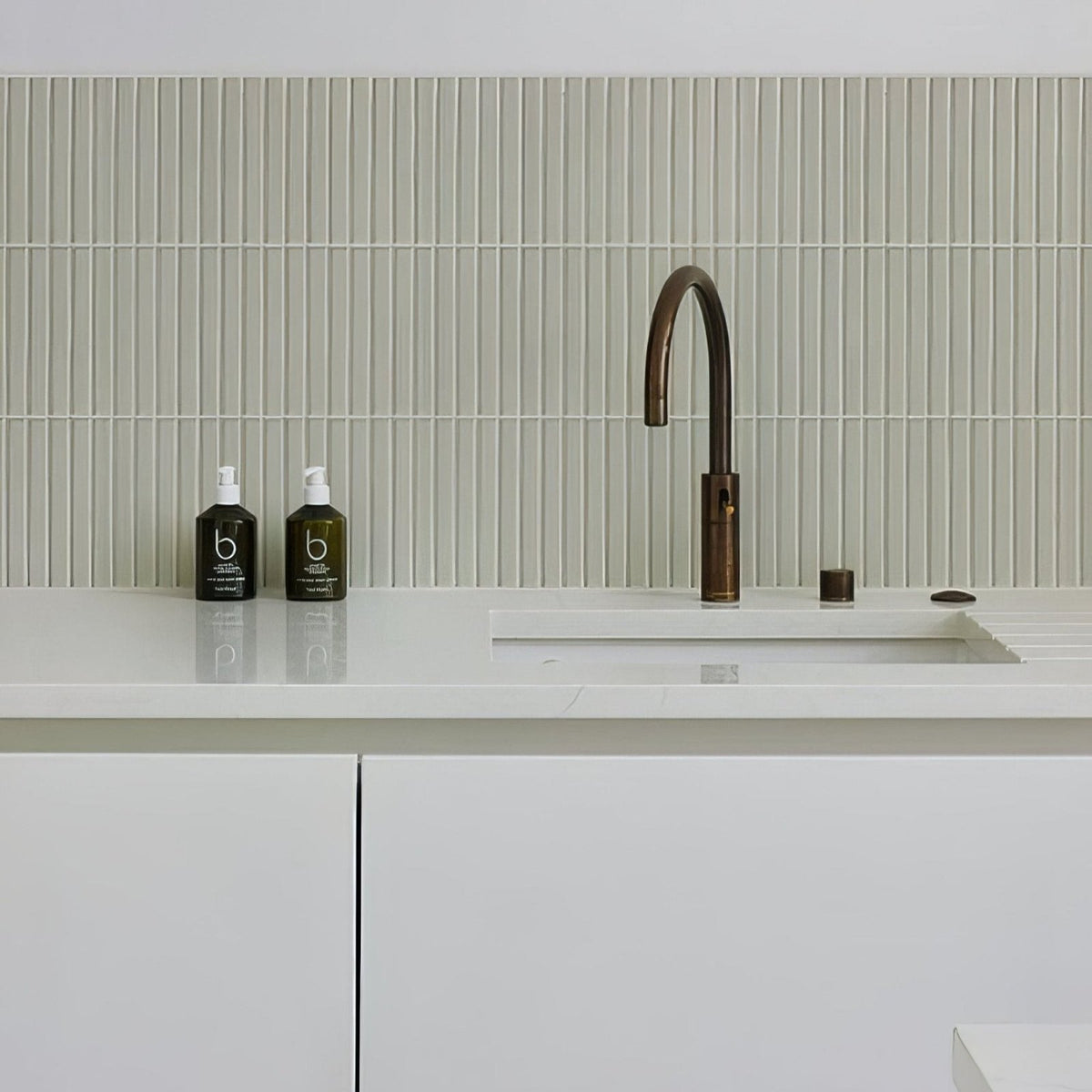Candy Cane Porcelain Mosaic Vanilla off-white ribbed porcelain mosaic behind a bronze kitchen tap
