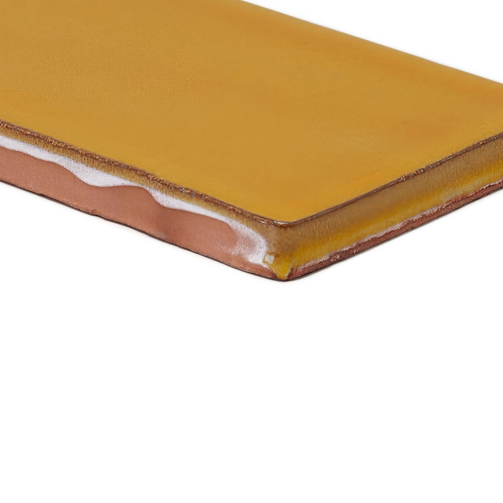 A rectangular mustard-yellow ceramic tile with a glossy finish and brownish edges carnival oro yellow glazed tile