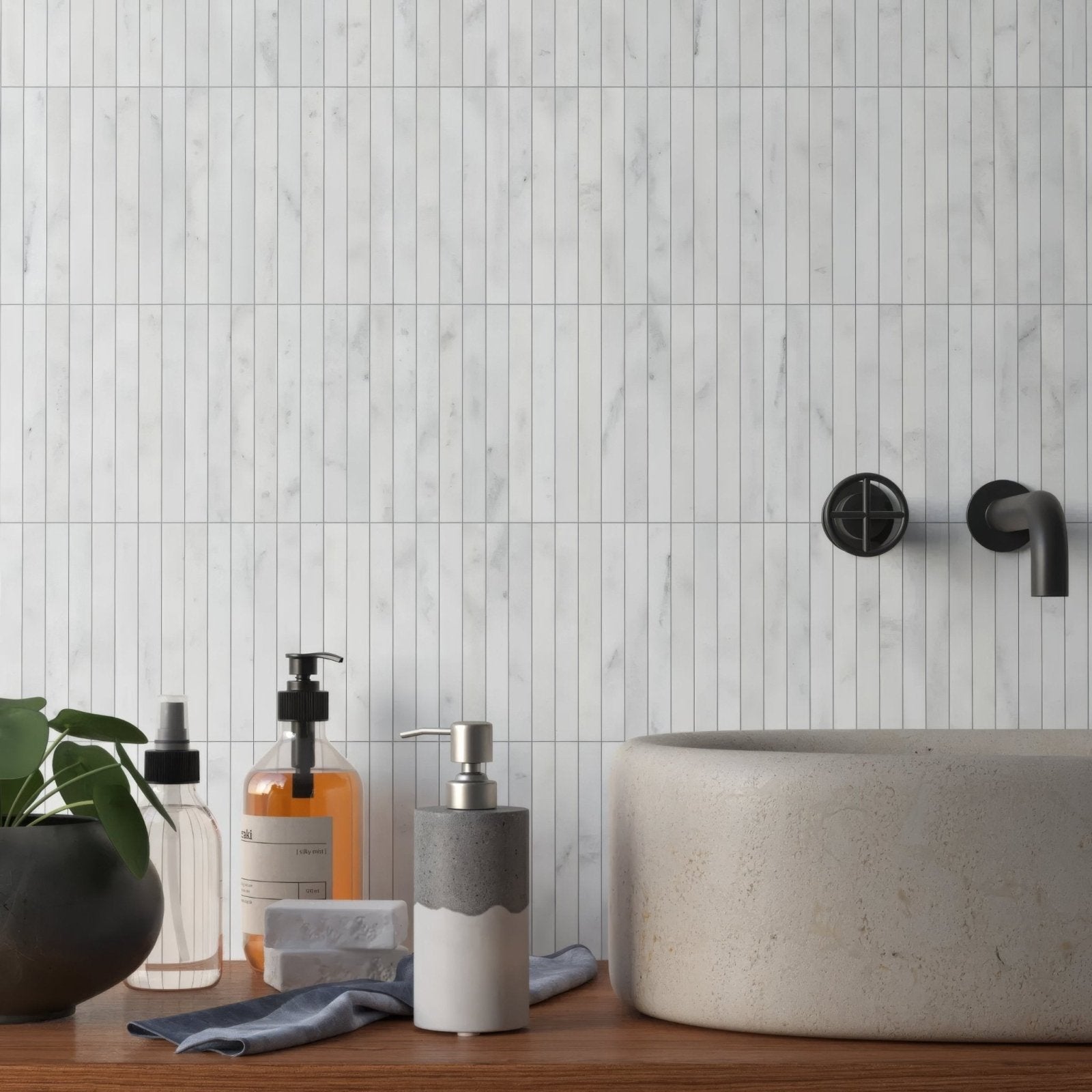 Carrara White Marble Kitkat Mosaic Tile white marble finger mosaic behind a concrete vessel sink