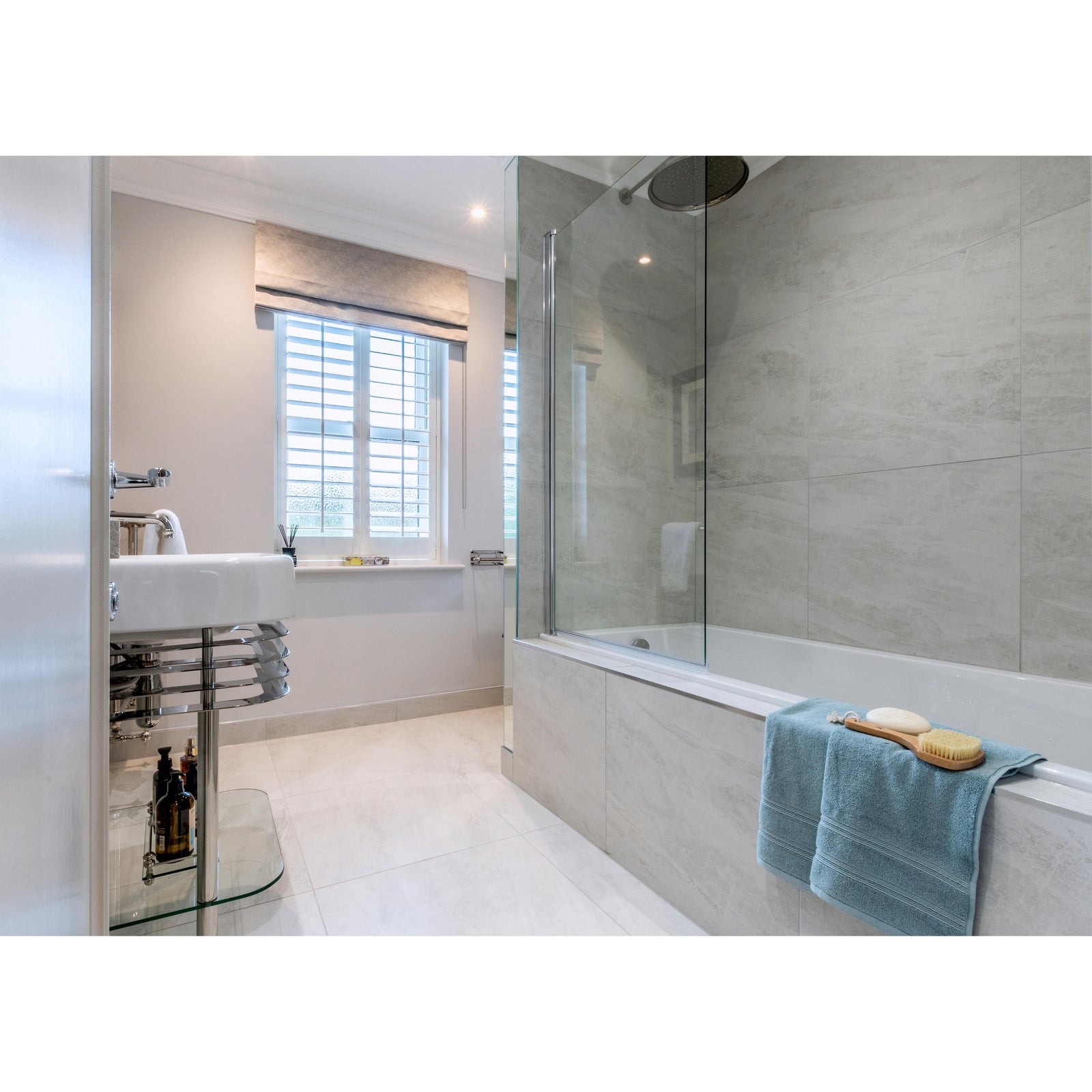Cashmire White 30 x 60cm cream marble-effect tiles with a light blue towel over a bathtub