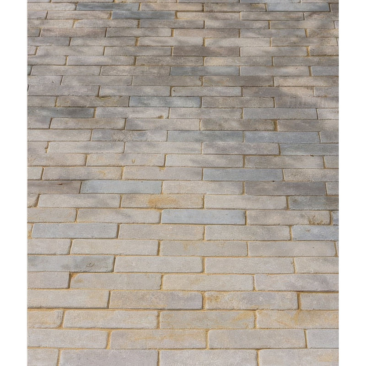 Castilan limestone tumbled klinkers in gray and beige rectangular paving stones arranged in a staggered brick pattern