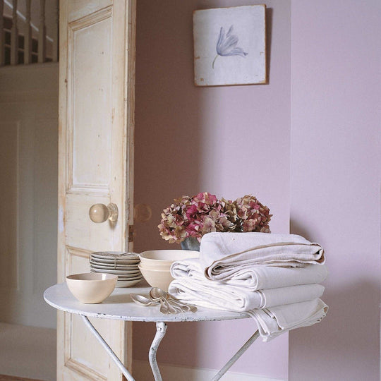 Stack of crisp white linen napkins folded neatly on a vintage white metal table in chalk violet product collection