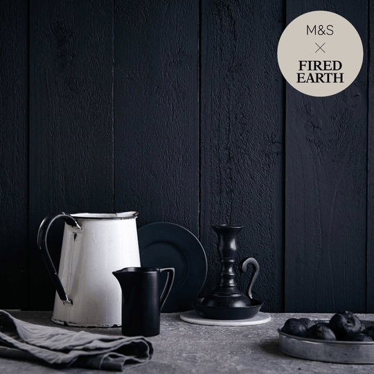 White enamel pitcher with black handle and rim featured in charcoal product collection for stylish serving