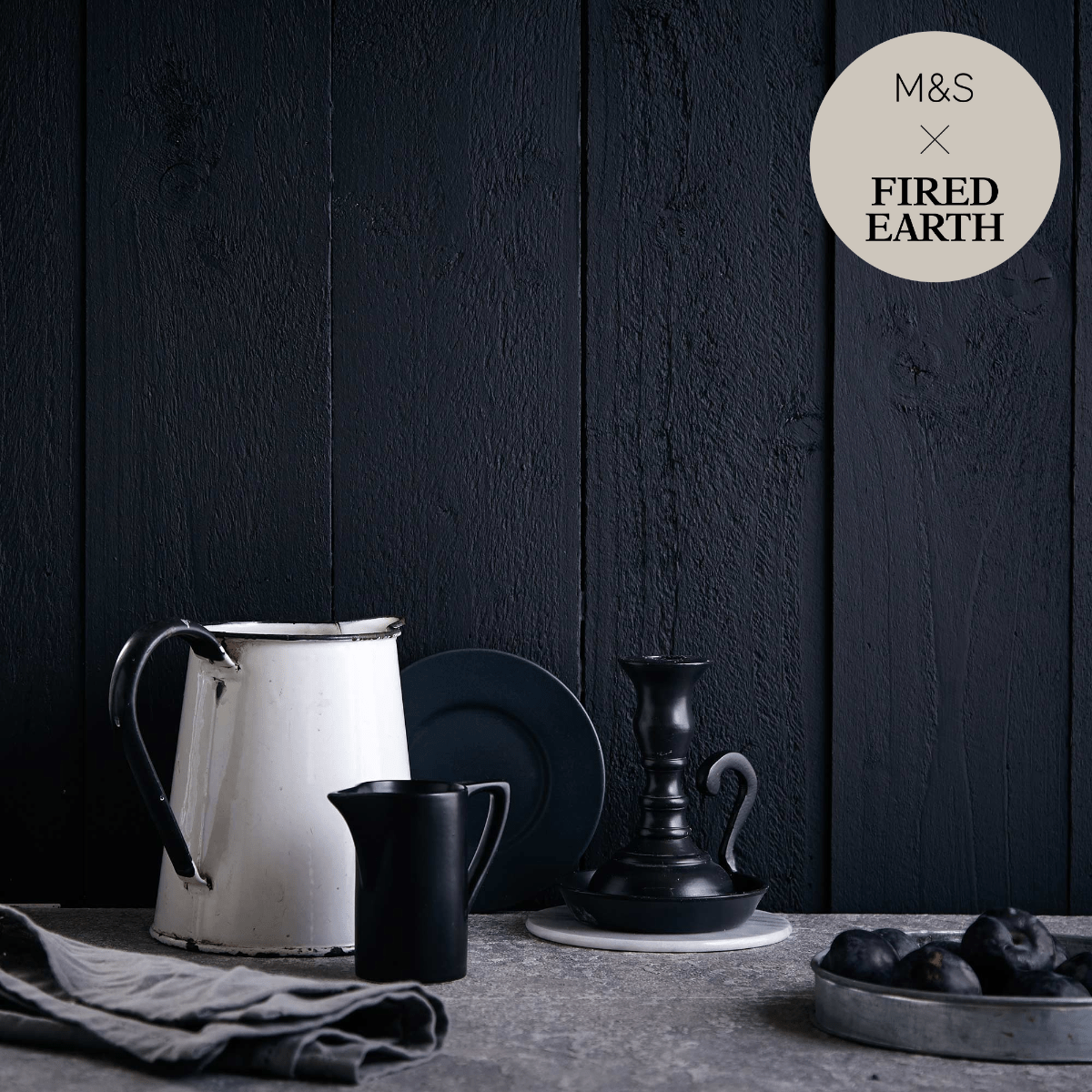 White enamel pitcher with black handle and rim featured in charcoal product collection for stylish serving