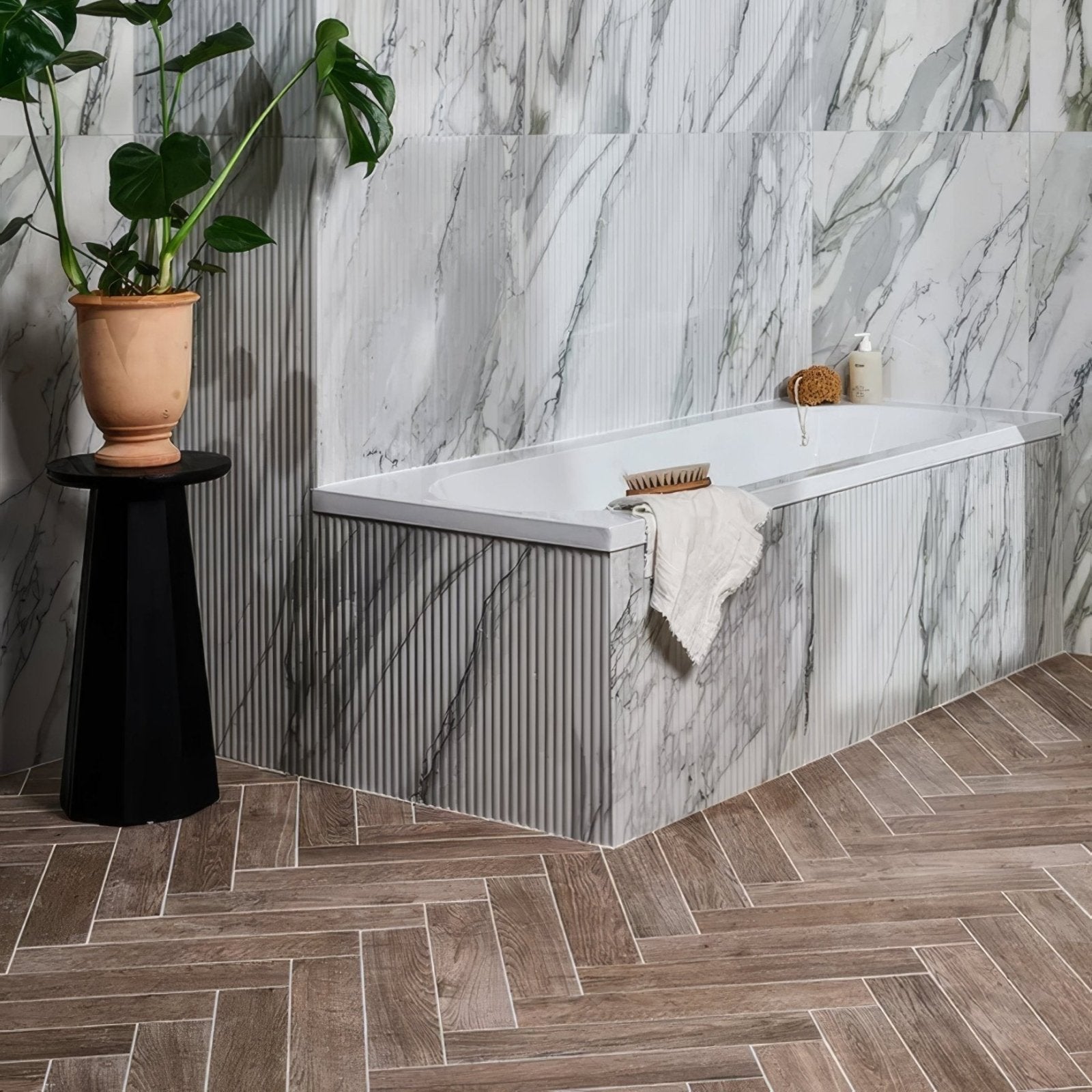 White bathtub with modern sleek design and marble patterned walls in chatham porcelain walnut bathroom setting
