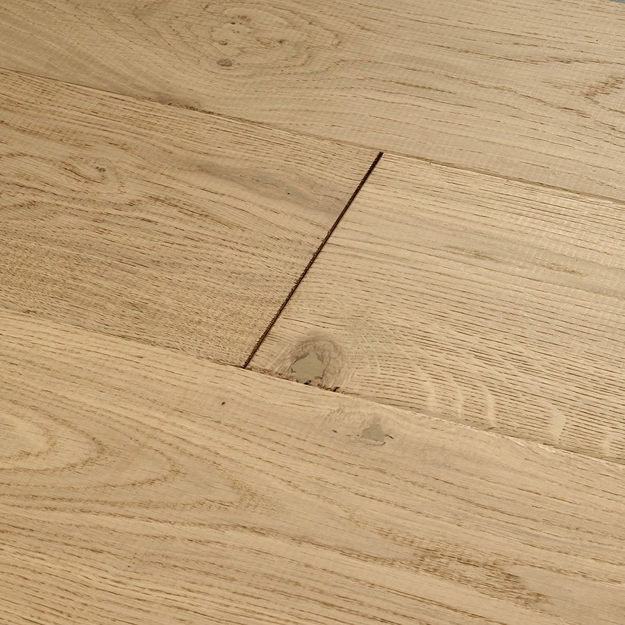 Light-colored oak hardwood floor planks with natural wood grain and subtle knots in chepstow flaxen oak finish