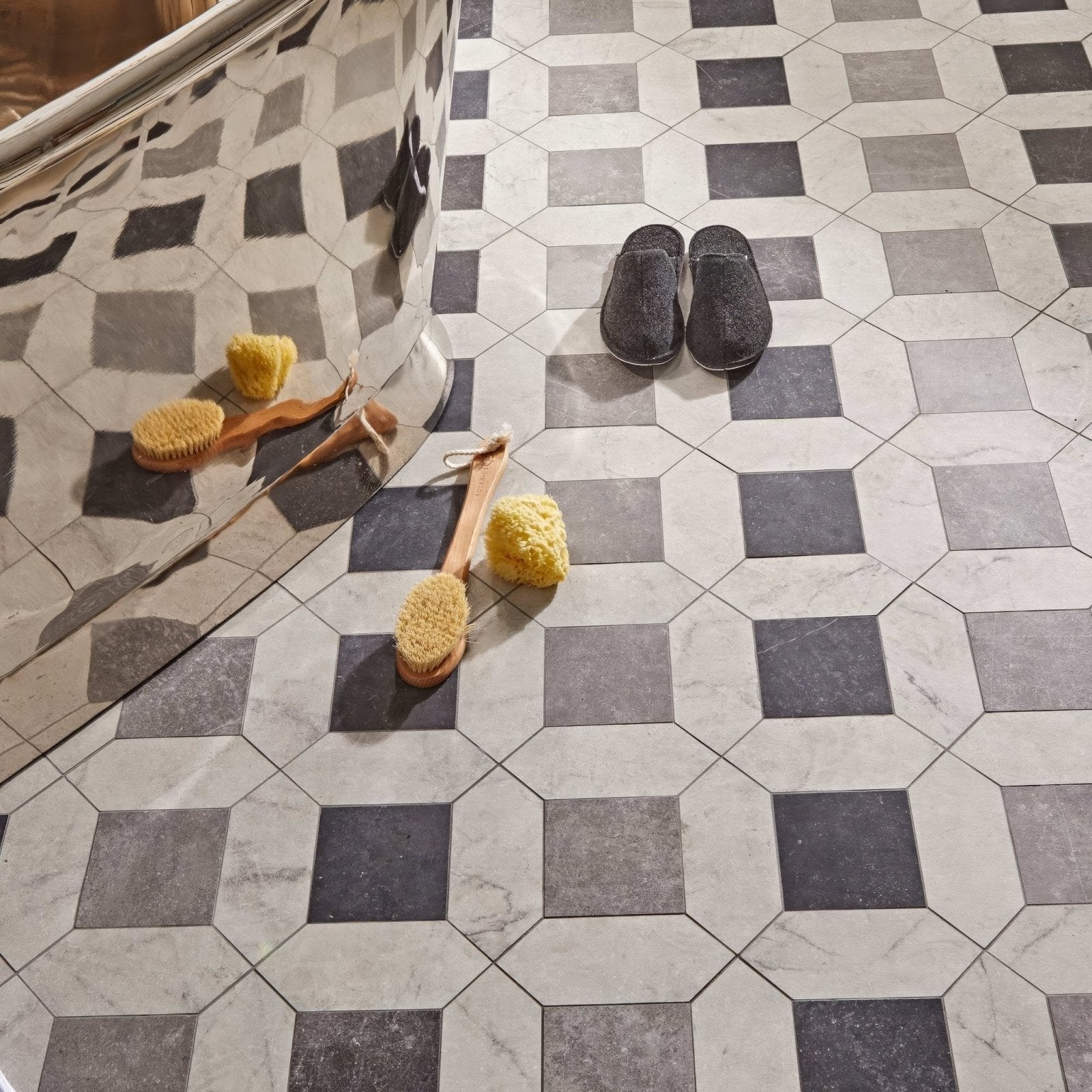 Chiesa black fuzzy slippers made of soft material sit neatly on a geometric tile floor