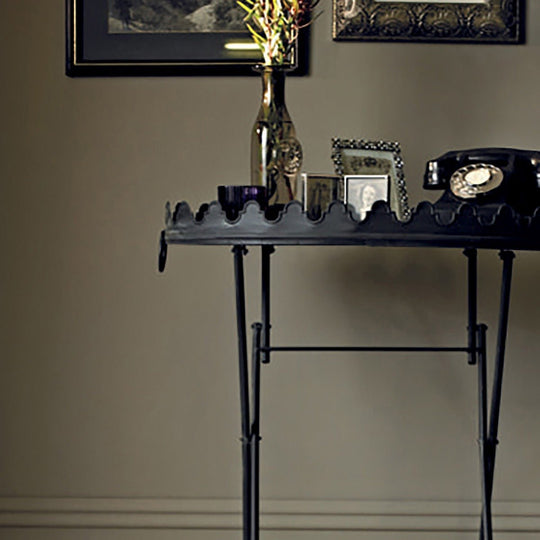 Black metal console table china clay with scalloped edge and slender legs for hallway or entryway use