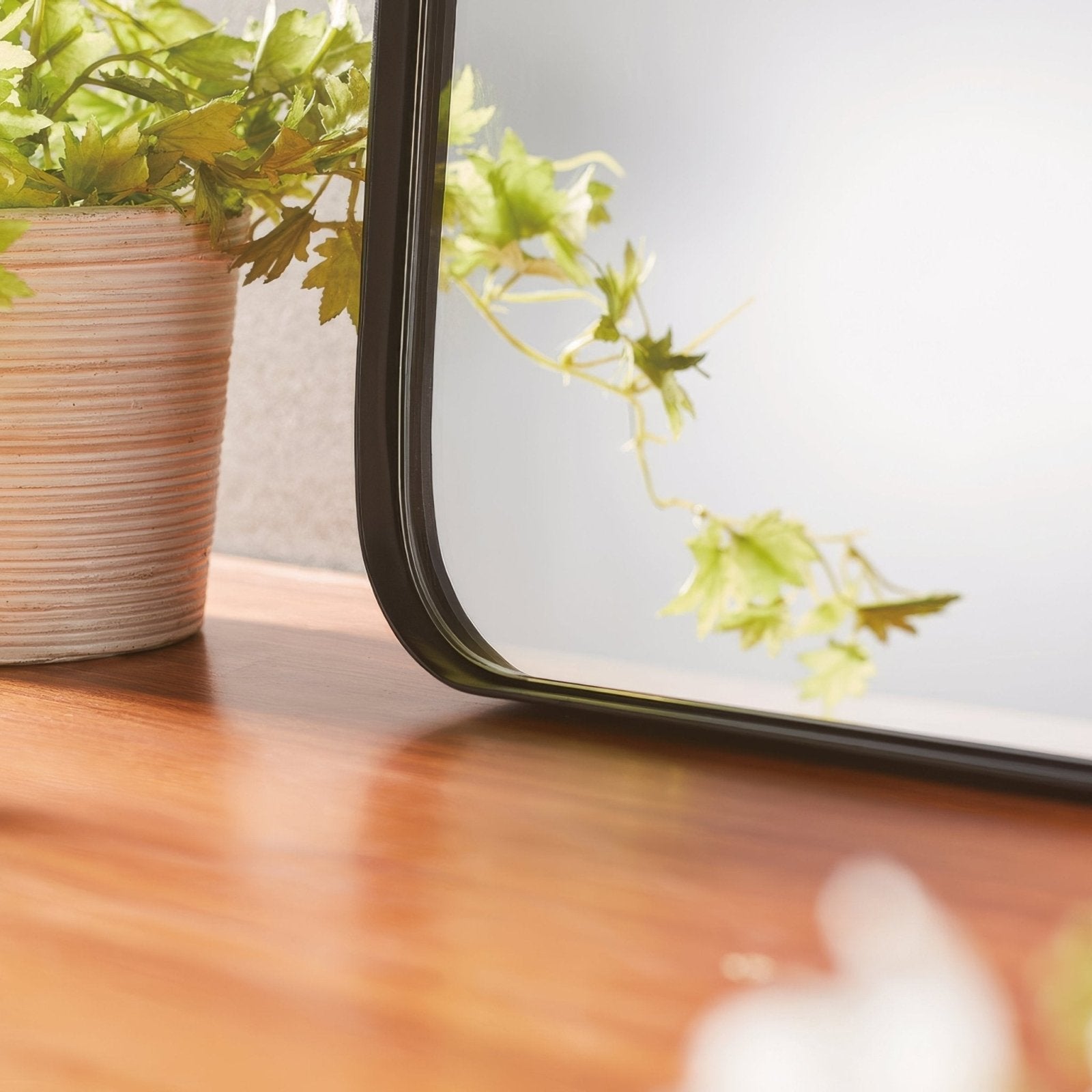 Black-framed rectangular City Mirror 50x75cm with a sleek modern design resting on a wooden surface