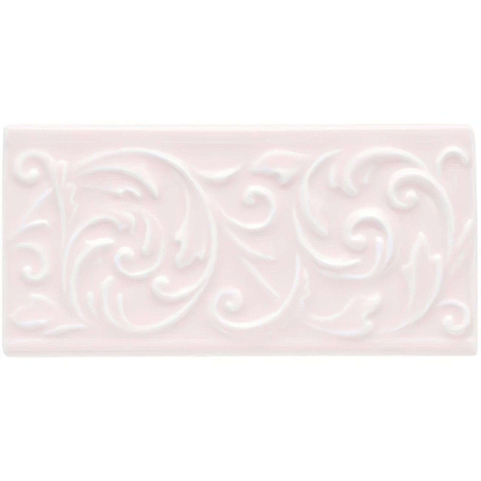 A rectangular matte-finished ceramic tile in soft blush pink with an elegant raised scrollwork pattern clare buckingham