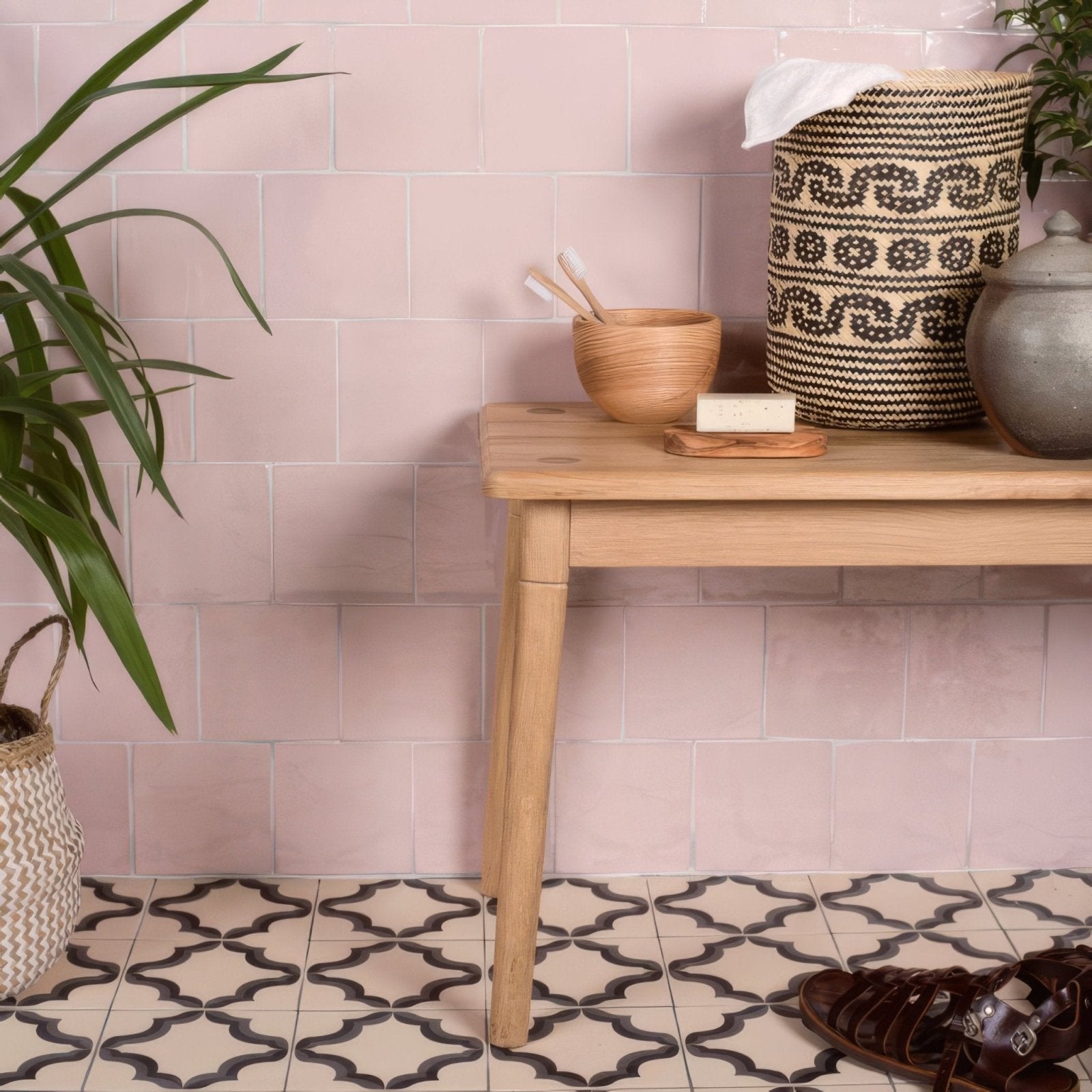 A woven black and white patterned storage basket with clover field tile design and a soft cloth draped over the top