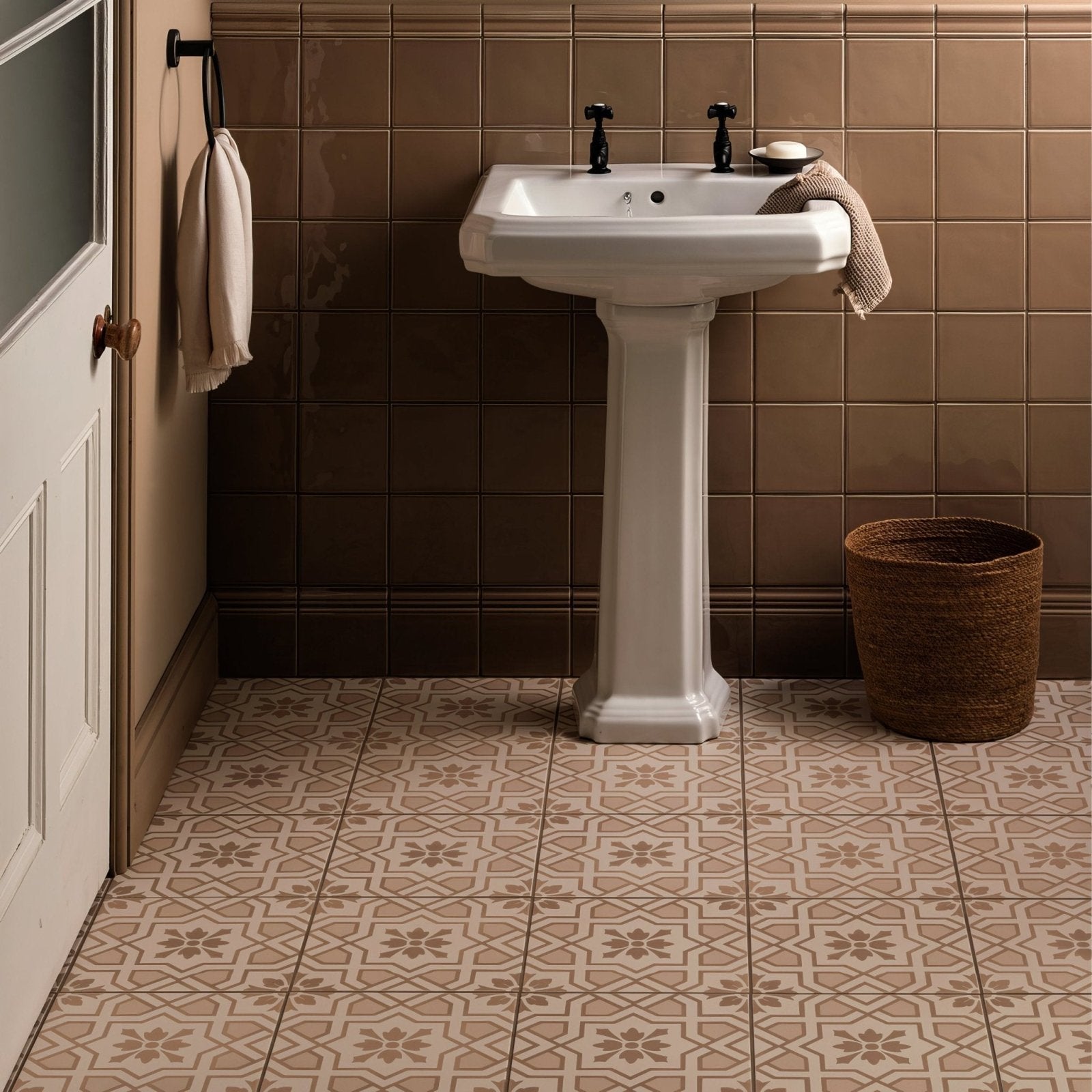 White ceramic pedestal sink with black faucet handles in cotehele taupe on chalk finish
