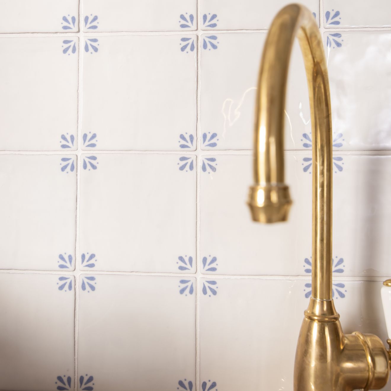 Gold-toned country delft cornelia kitchen faucet with sleek curved spout and polished finish